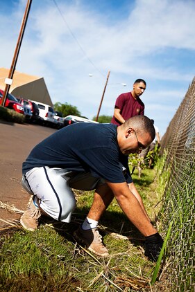 Cpl. Antonio Garcia and Sgt. Juan Gutierrez, wiremen with Headquarters Company, 1st Battalion, 12th Marine Regiment, remove weeds from a chain-link fence while volunteering at the Waianae Civic Center in Waianae, Hawaii, Dec. 17, 2010. Only hours before departing on winter holiday leave, 20 Headquarters Co. Marines volunteered their time to clean up the grounds of the center, which houses homeless veterans and their families. Opened in 2007 by Hawaii Gov. Linda Lingle, the center is operated by the United States Veterans Initiative, the nation’s largest non-profit provider of services to veterans facing challenges in their transition to civilian life. It provides housing and transitional programs for approximately 275 people.