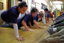Zoekia Matthews, 19, from St. Paul, Minn., maintains her focus while a few of her fellow poolees rest during a physical training session at the University of Minnesota Armory Dec. 18. Matthews, a Como Park High School graduate recruited out of Roseville, Minn., will depart for Marine Corps boot camp May 16, 2011.::r::::n::