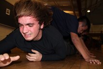 Shane Peas, 18, from Mounds View, Minn., low crawls underneath his fellow poolees during a physical training session at the University of Minnesota Armory Dec. 18. Peas, a senior at Irondale High School recruited out of Marine Corps Substation Roseville, will depart for boot camp June 13, 2011.::r::::n::