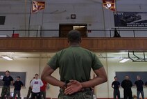 Pvt. Cecil Howard, 19, from New Brighton, Minn., demonstrates how to properly execute drill movements to more than 30 Marine applicants during a Recruiting Substation Roseville poolee function at the University of Minnesota Armory Dec. 18. Howard, a Mounds View High School graduate, completed boot camp Nov. 24.