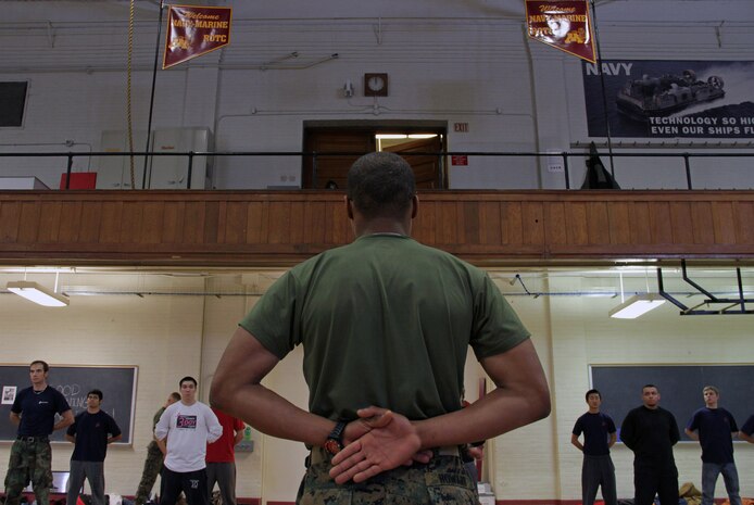 Pvt. Cecil Howard, 19, from New Brighton, Minn., demonstrates how to properly execute drill movements to more than 30 Marine applicants during a Recruiting Substation Roseville poolee function at the University of Minnesota Armory Dec. 18. Howard, a Mounds View High School graduate, completed boot camp Nov. 24.