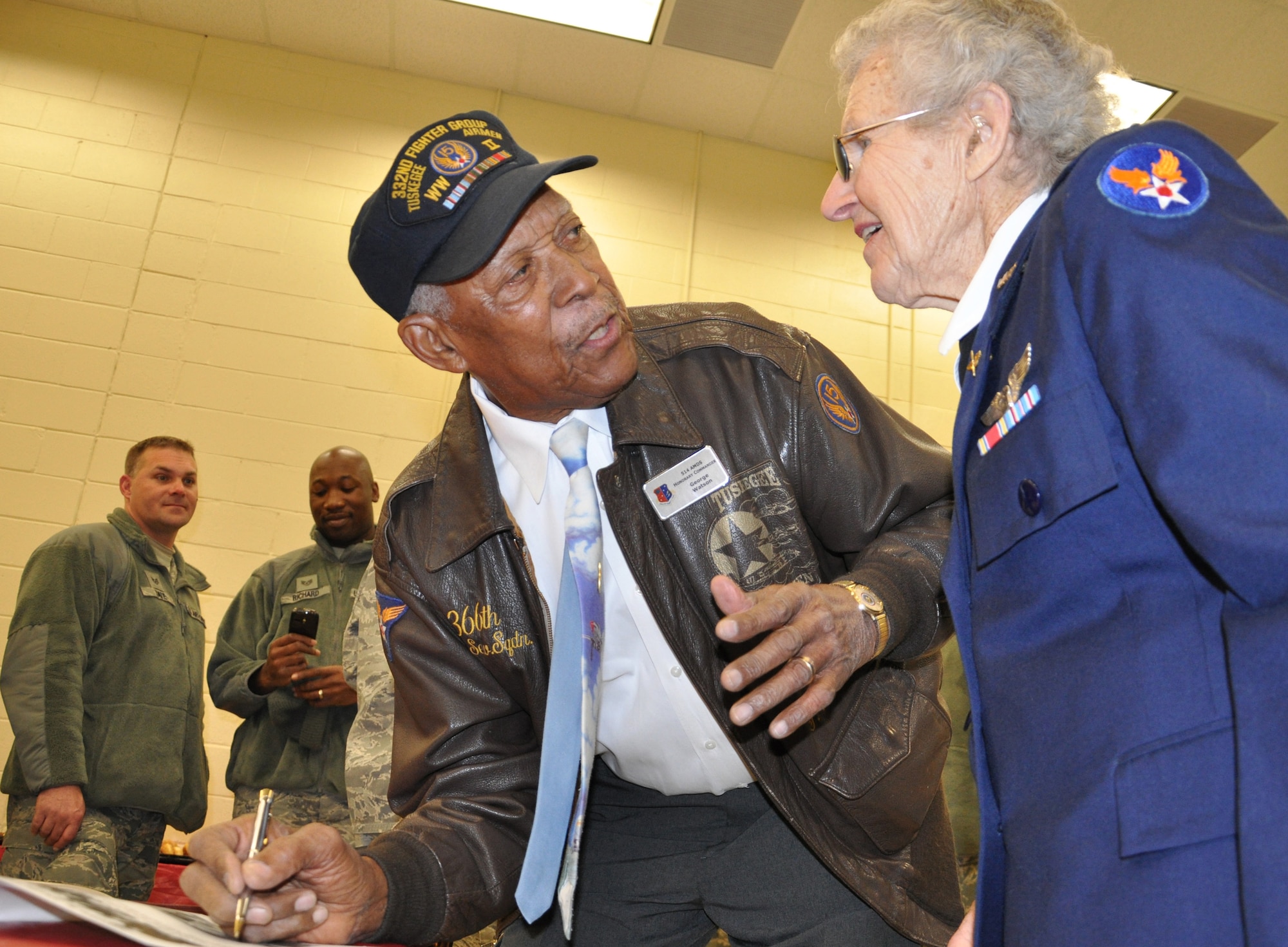 JOINT BASE MCGUIRE-DIX-LAKEHURST, N.J. -- Mr. George Watson a World War II veteran and documented Tuskegee Airmen gives Mrs. Lillian Yonally, a Woman Airforce Service Pilot, his autograph during the 514th Air Mobility Wing 22nd Annual Holiday breakfast, held Dec. 16, here. (Air Force photo/Master Sgt. Donna T. Jeffries) 