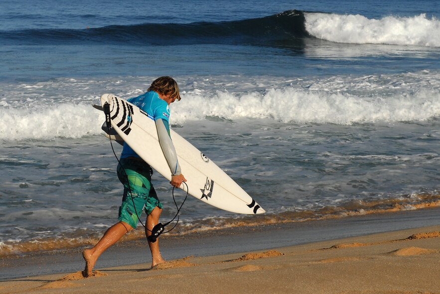 Adrain Buchan, a professional surfer, retrieves a new surf board after breaking his in a quarter-finals matchup against Kelly Slater at Pipeline on Sunset Beach, North Shore of Oahu, Hawaii, during the quarter-final heat of the Billabong Pipe Masters , In memory of Andy Irons, Dec. 16. The culminating event of the Triple Crown of Surfing series is the longest running professional surfing event in the world. (U.S. Air Force photo/Staff Sgt. Mike Meares)