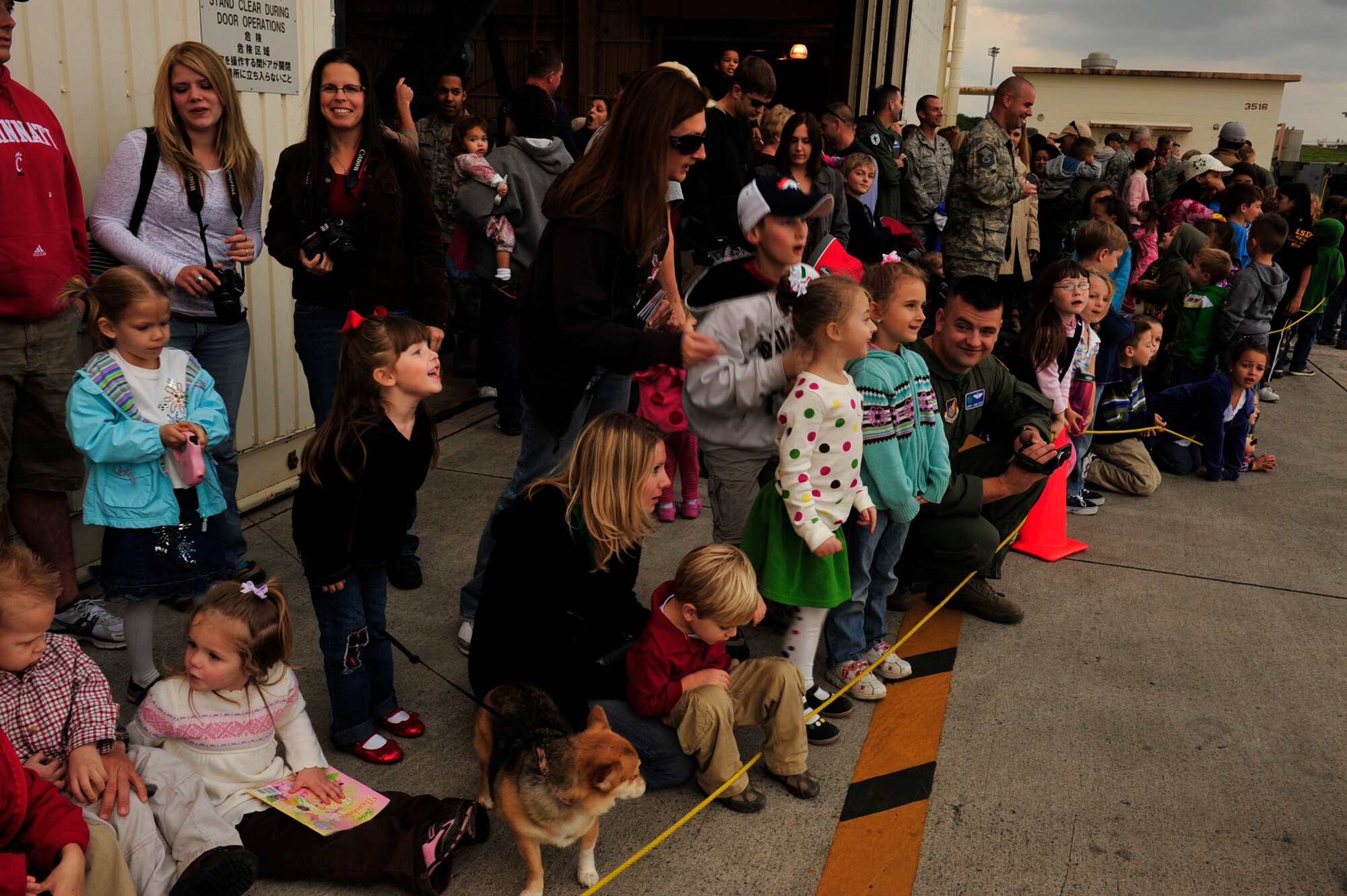 Members of the 33rd and 31st Rescue Squadron wait anxiously with their children for Santa Claus and one of his elves to arrive via helicopter at Kadena Air Base, Dec. 17. Once on the ground, Santa and his elf greeted the children of the squadrons and gave each of them a gift. (U.S. Air Force photo/Staff Sgt. Lakisha A. Croley)