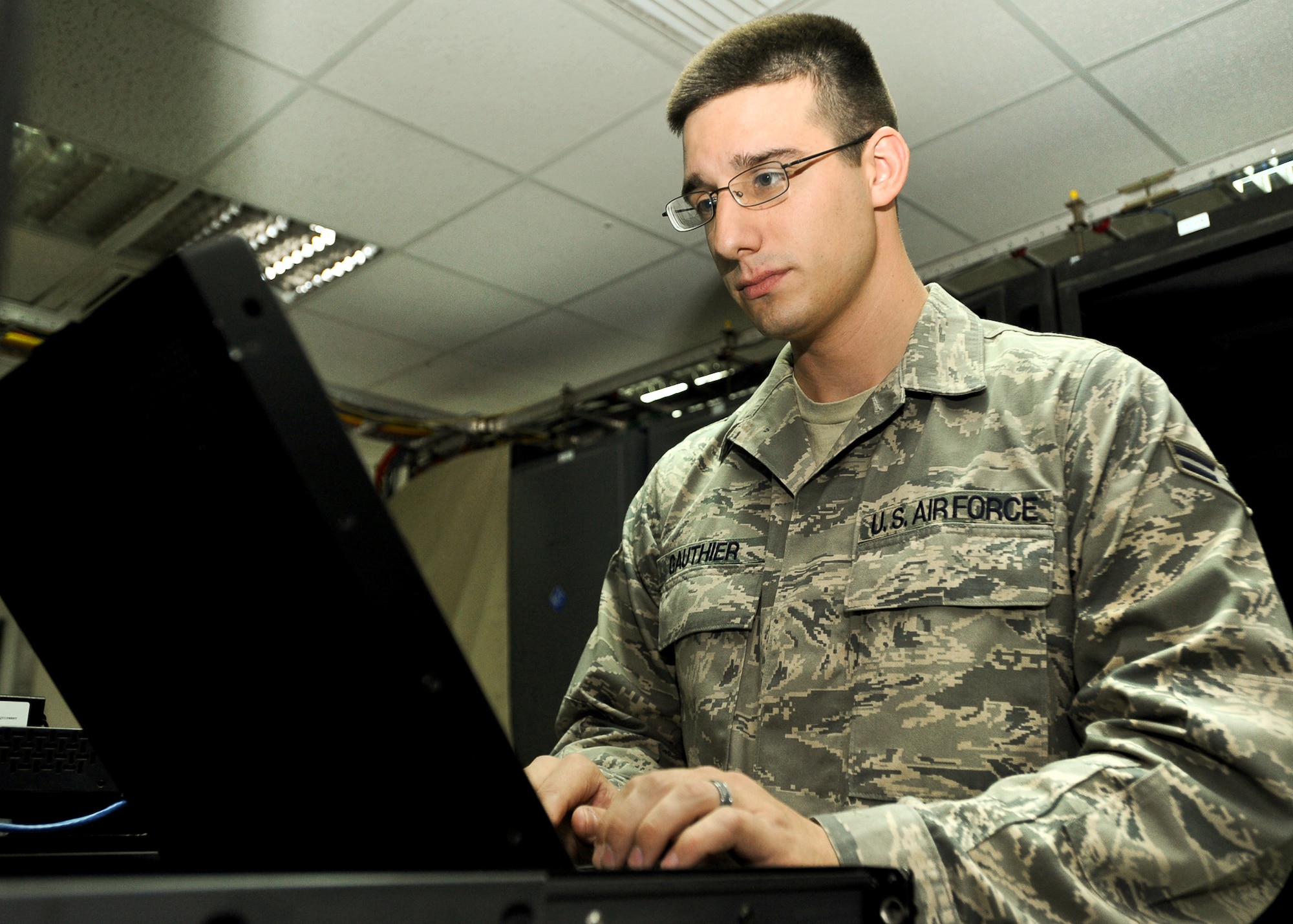 SOUTHWEST ASIA - Airman 1st Class Christopher Gauthier of the 386th Expeditionary Communications Squadron monitors the servers used to control DAWGnet Dec. 16, 2010, at an undisclosed air base in Southwest Asia. The free, wireless morale network provides commercial Internet access to more than 2,000 U.S. Service members and civilians assigned to the 386th Air Expeditionary Wing. (U.S. Air Force photo by Senior Airman Laura Turner)