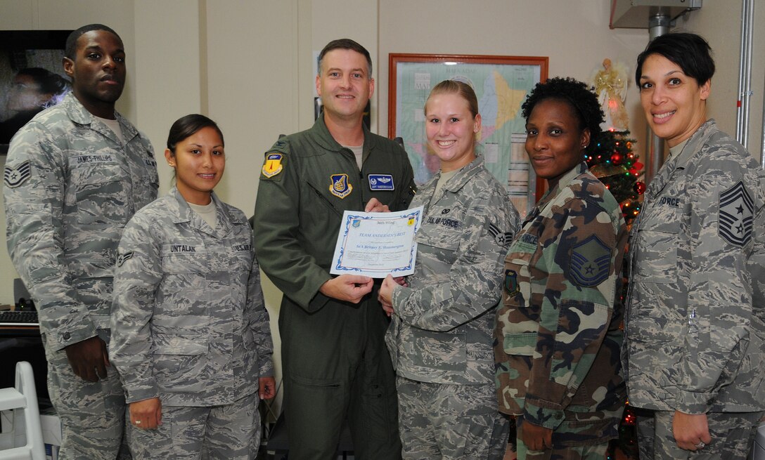 Senior Airman Britney Hammergren (center), 36th Wing Command Post senior controller, stands with her peers after being awarded Andersen’s Best here Dec. 9.
As senior controller Airman Hammergren was recognized as one of the top controllers and certified as a senior controller, aposition normally held by staff sergeants and above. (U.S. Air Force photo/Senior Airman Nichelle Anderson) 
