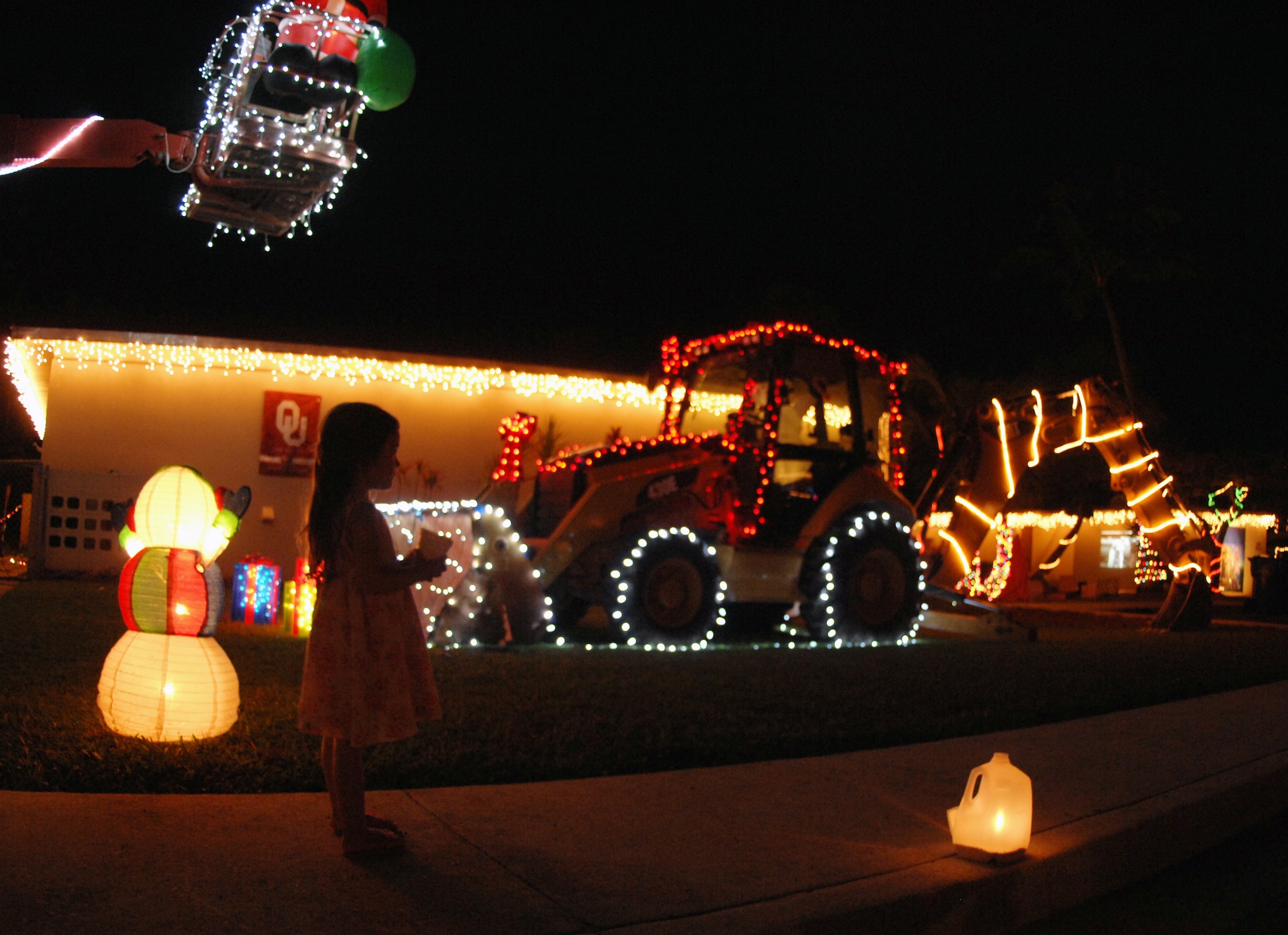 A child admires an illuminated street during Rota Walk Dec. 18, an annual pilgrimage down Rota Drive, and one of Team Andersen’s most beloved traditions. More than 50 houses were adorned with lights and decorations that represented each commander’s respective unit.  The event hosted a number attractions including a live Nativity scene hosted by the Andersen Chapel, gospel and elementary school choirs singing carols, and a performance by the Guam High School and Air Force Alaska Brass Band at the 36th Wing Commander, Brig. Gen. John Doucette's house. (U.S. Air Force photo/ Airman 1st Class Anthony Jennings)