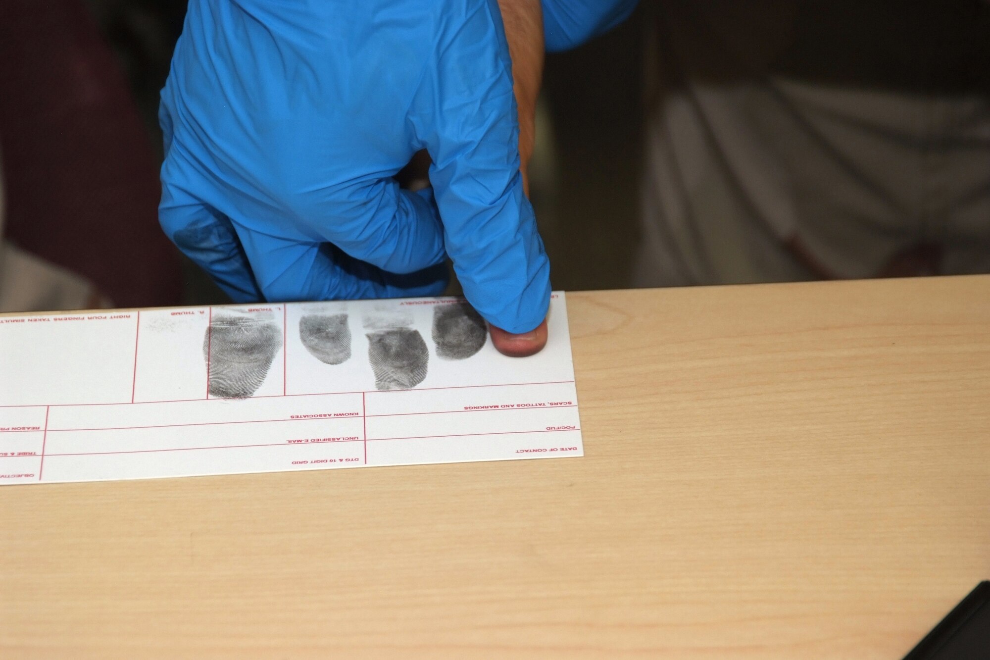 A Six3 Systems instructor helps 4th Combat Camera Airmen they practice fingerprinting techniques. The four-day battlefield forensics course was the first for an Air Force unit. (U.S. Air Force photo/ Tech. Sgt. Joseph Zuccaro)