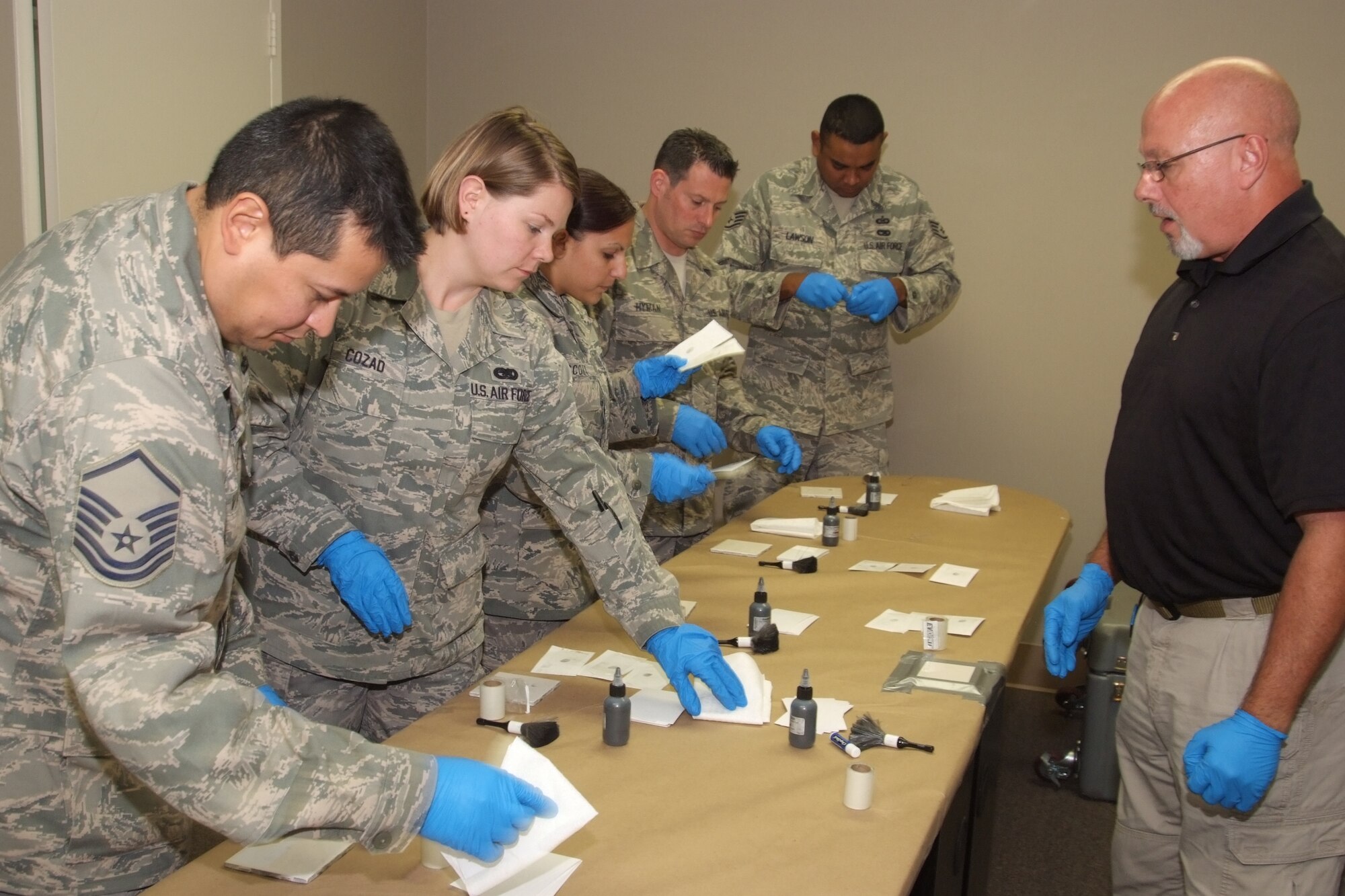 A Six3 Systems instructor helps 4th Combat Camera Airmen they practice fingerprinting techniques. The four-day battlefield forensics course was the first for an Air Force unit. (U.S. Air Force photo/ Tech. Sgt. Joseph Zuccaro)