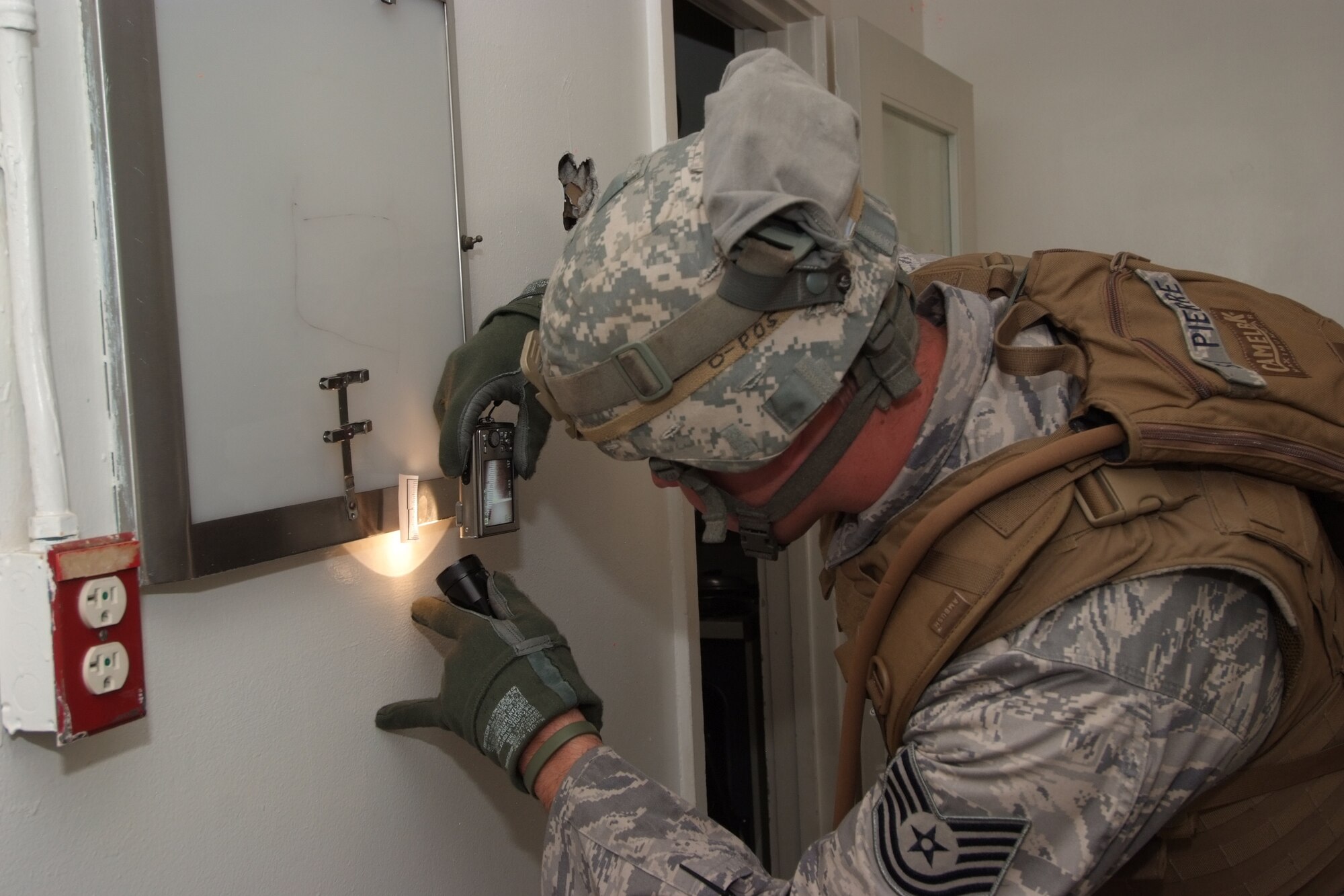 Tech. Sgt. Daniel St. Pierre, 4th Combat Camera Squadron, takes a photograph of a piece of evidence during a battlefield forensics course. (U.S. Air Force photo by Tech. Sgt. Joseph Zuccaro)
