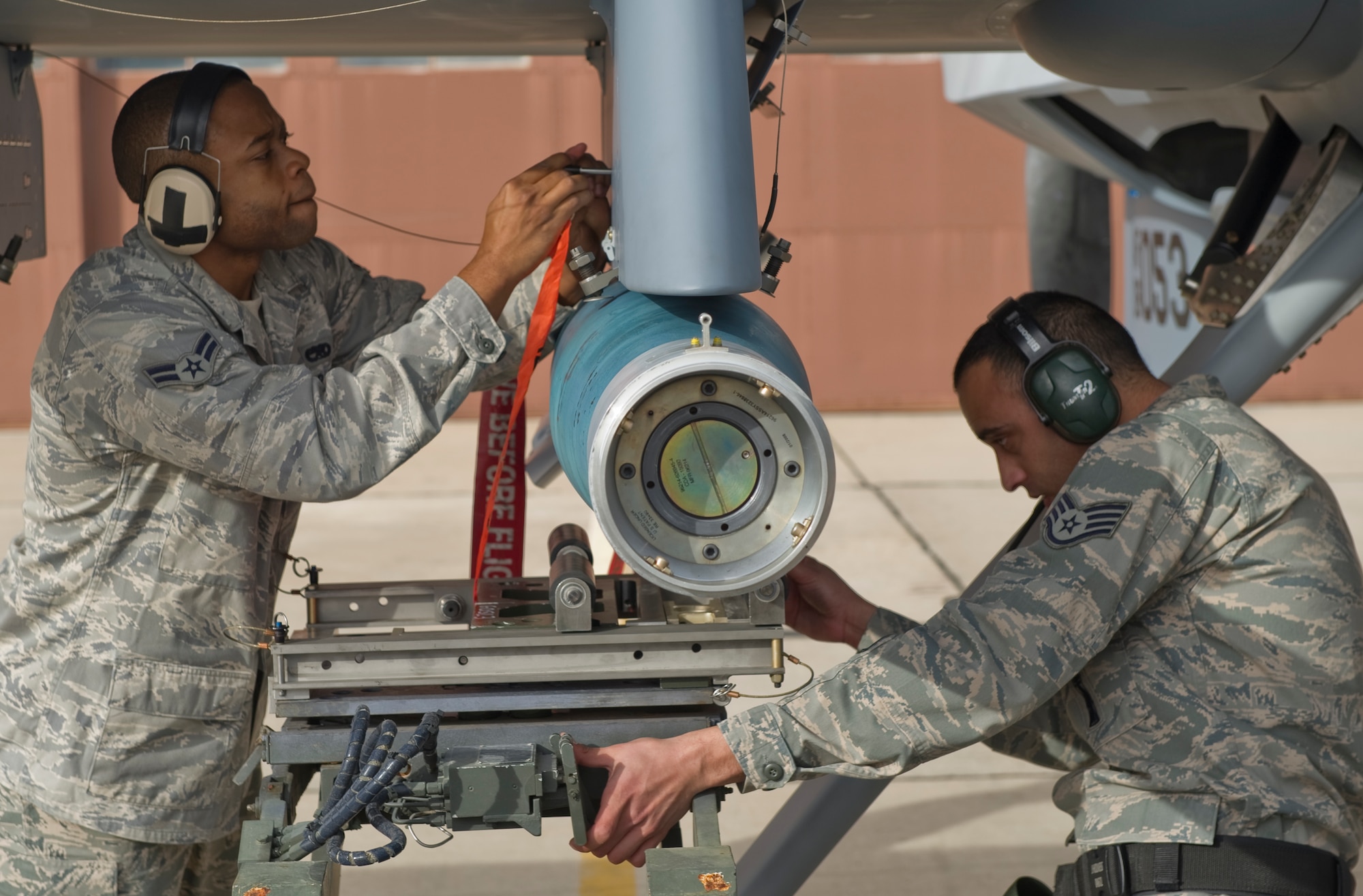 HOLLOMAN AIR FORCE BASE, N.M. -Staff Sgt. James Holness and Airman 1st Class Samuel Williams, both with the 849th Aircraft Maintenance Squadron, tighten sway braces during the December load crew competition Dec. 17, 2010. Weapons load crew competitions are held every quarter to test each Airman's ability to follow safety and technical orders while loading an MQ-9 Reaper and an F-22 Raptor. A traveling trophy is awarded to each winning crew. (U.S. Air Force photo by Airman 1st Class Joshua Turner/Released)