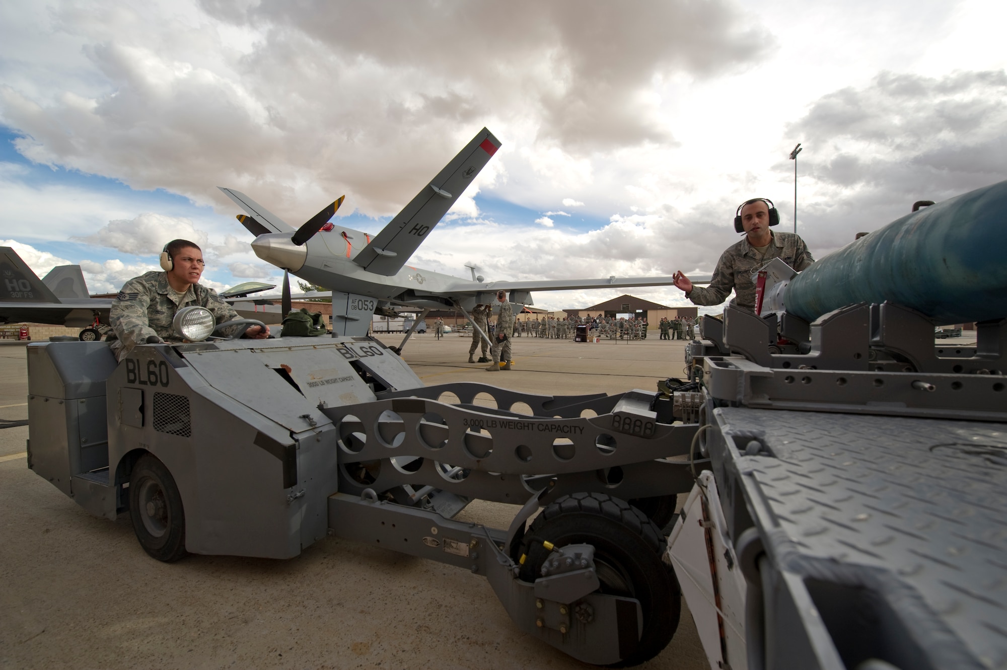 HOLLOMAN AIR FORCE BASE, N.M. - Staff Sgt. James Holness signals Staff Sgt. Kyle Bush, both with the 849th Aircraft Maintenance Squadron, during the December load crew competition Dec. 17, 2010. Weapons load crew competitions are held every quarter to test each Airman's ability to follow safety and technical orders while loading an MQ-9 Reaper and an F-22 Raptor. A traveling trophy is awarded to each winning crew. (U.S. Air Force photo by Airman 1st Class Joshua Turner/Released)