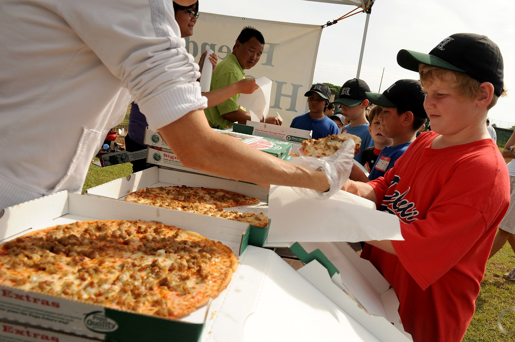 After a day of fundamental baseball training, the children were treated to pizza and hot dogs during the Friends of Hickam baseball clinic Dec. 18. Hickam and Pearl Harbor children were taught baseball fundamentals by University of Hawaii and Hawaii Pacific University coaches and players duringthe event. The baseball clinic is the first of an annually planned event for the Friends of Hickam. (U.S. Air Force photo/Staff Sgt. Mike Meares)