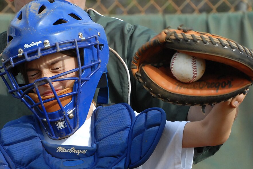 Isabel Green, 9, flinches as a baseball hits her mit during catchers practice Dec. 18 at the Friends of Hickam baseball clinic. Hickam and Pearl Harbor children were taught baseball fundamentals by University of Hawaii and Hawaii Pacific University coaches and players duringthe event. The baseball clinic is the first of an annually planned event for the Friends of Hickam. (U.S. Air Force photo/Staff Sgt. Mike Meares)