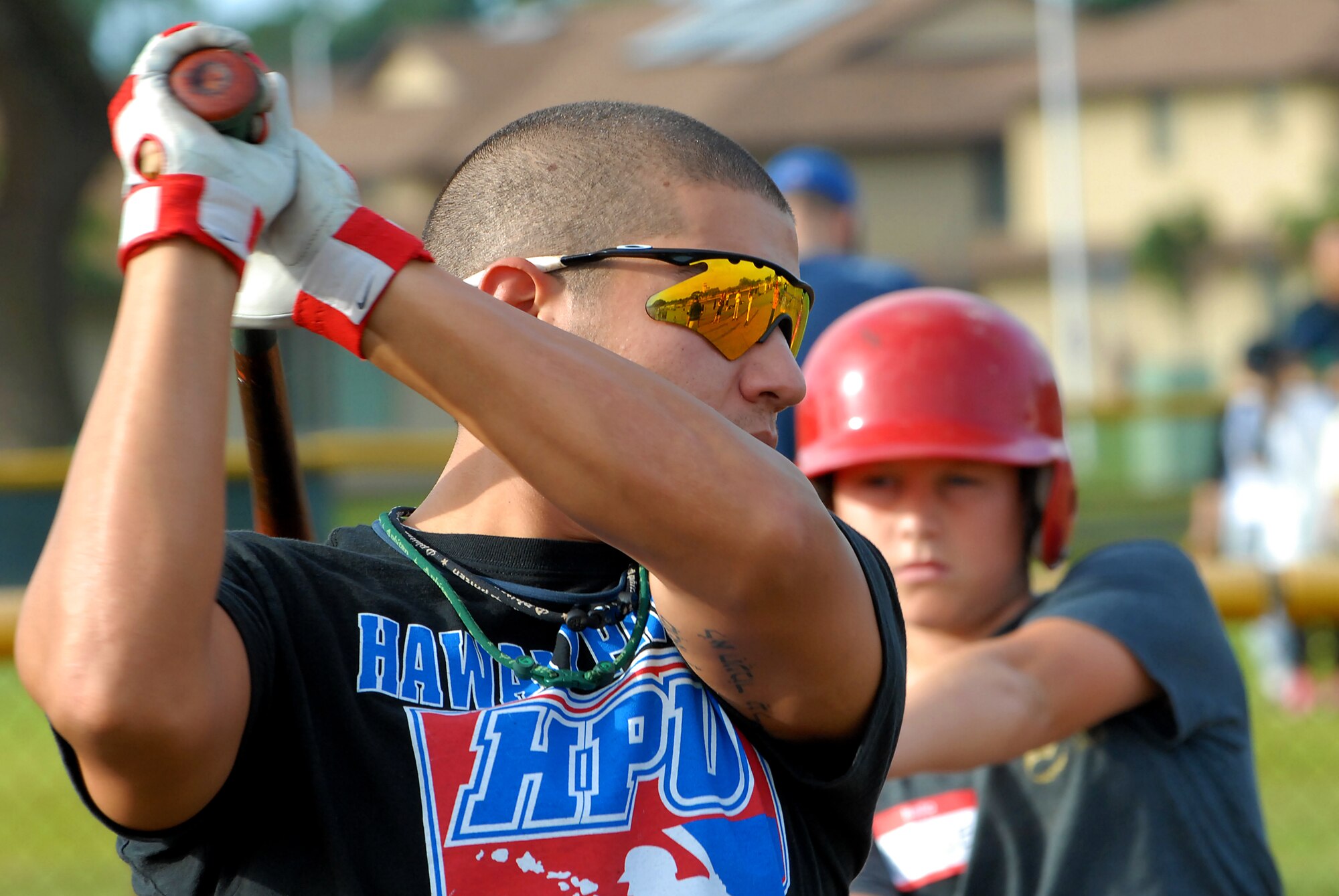 David Greenstein, Hawaii Pacific University junior outfielder, shows the children at the baseball clinic the proper technique and follow through while swinging a bat Dec. 18. Hickam and Pearl Harbor children were taught baseball fundamentals by University of Hawaii and Hawaii Pacific University coaches and players duringthe event. The baseball clinic is the first of an annually planned event for the Friends of Hickam. (U.S. Air Force photo/Staff Sgt. Mike Meares)