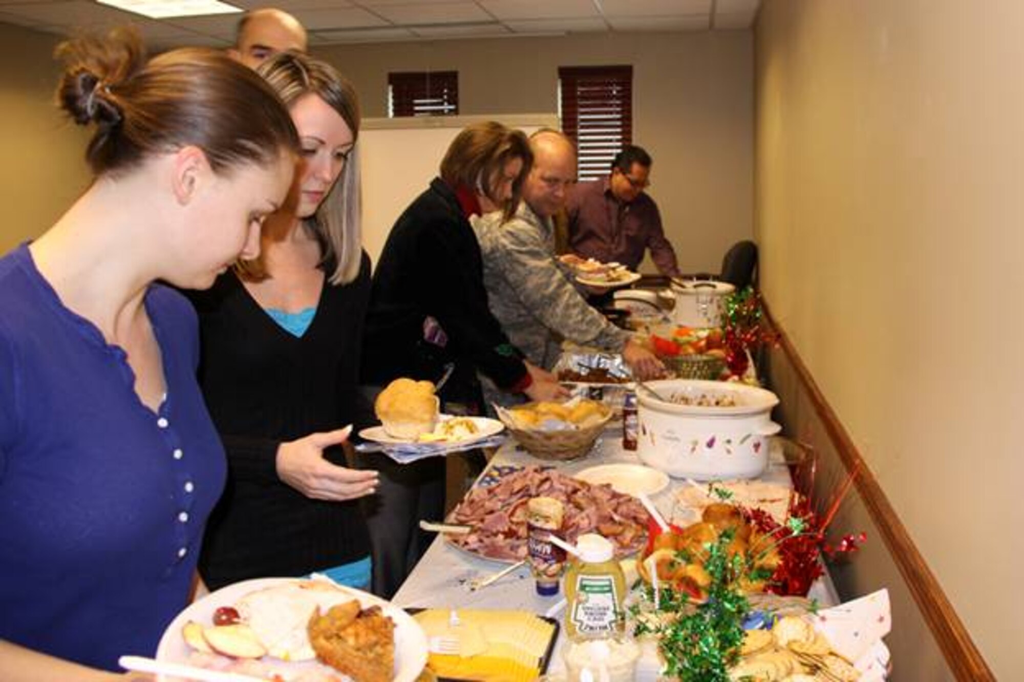 Full-time personnel from the 911 Airlift Wing enjoy a holiday pot-luck lunch in the headquarters building, Thursday, Dec. 16, 2010. Employees brought a personal dish, which allowed everyone to share both food and fellowship this holiday season.