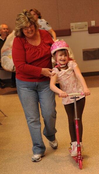 Mollie Petty, 7, rides her new scooter during the Santa's in Blue event at the Bossier City Civic Center in Bossier City, La., Dec. 18. Santa's in Blue is a program sponsored by the Air Force Sergeants Association and Barksdale Top Three to provide gifts for more than 400 children in foster care. (U.S. Air Force photo/Airman 1st Class Sean Martin)(Released)
