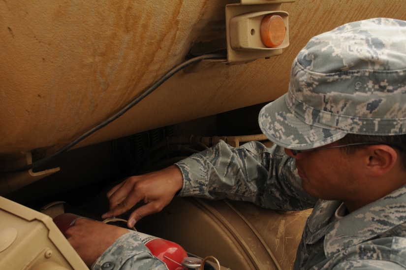 SOTO CANO AIR BASE, Honduras - Staff Sgt. Josue Santiago inspects the outside of a Heavy Expanded Mobility Tactical Truck-M978 A3. Petroleum, Oil and Lubricant shop troops here trained on the new capabilities and functions of the 9 newest fleet additions Dec. 13. (U.S. Air Force photo/Staff Sgt. Kimberly Moore)