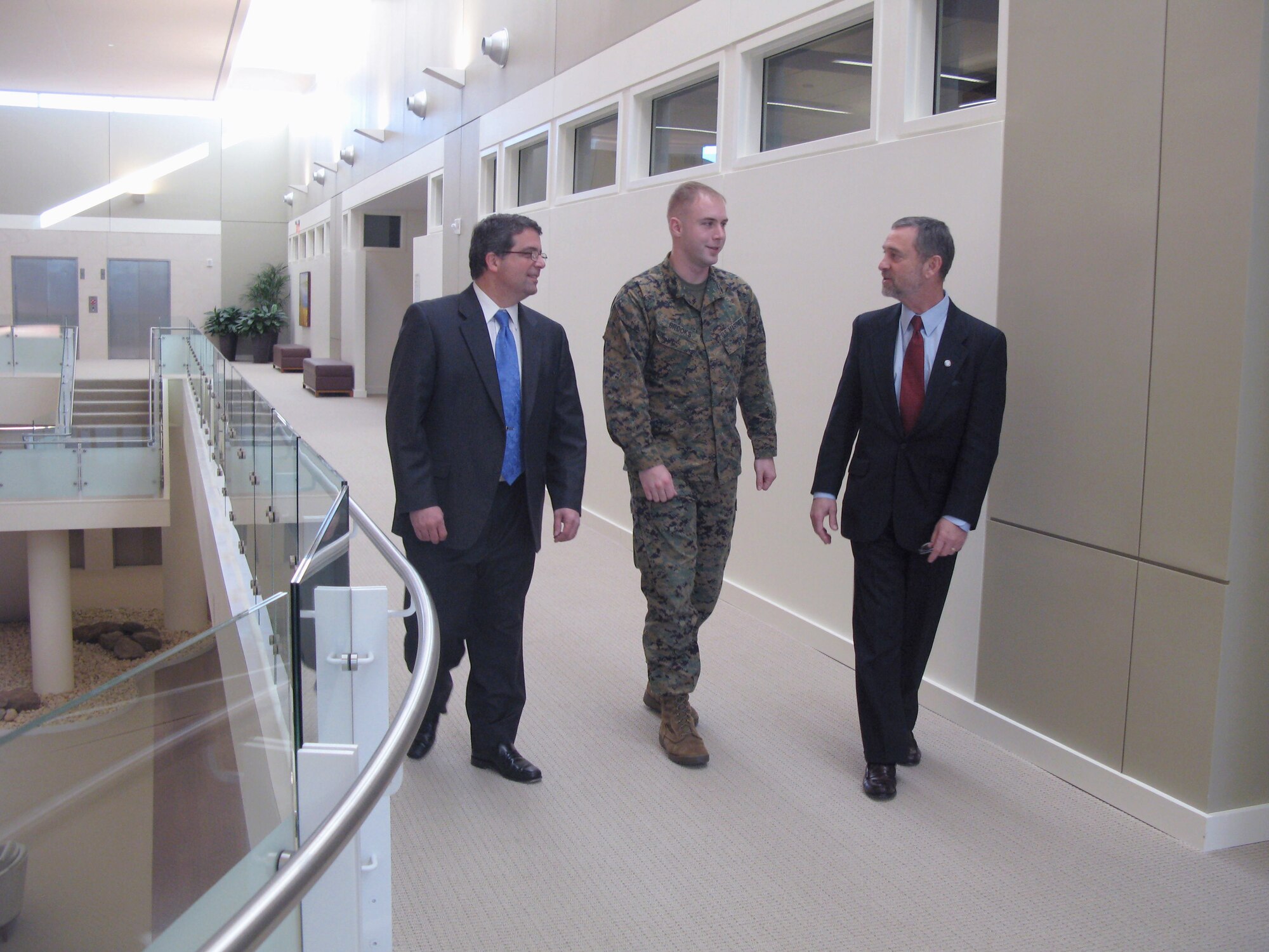 Marine Corps Sgt. Tim Brooks talks with Dr. James Kelly, right, and Dr. Thomas J. DeGraba about the care Sergeant Brooks is receiving. Sergeant Brooks suffered a traumatic brain injury after being exposed to a rocket attack and three improvised-explosive-device attacks in Iraq. Dr. Kelly is the director of the National Intrepid Center of Excellence. Dr. DeGraba is the center's deputy director. (DOD photo/Donna Miles) 