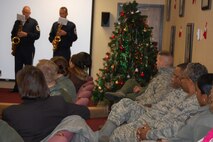 Airmen from the 916th Air Refueling Wing listen to holiday music provided by the Air Force Heritage Band Saxophone Quartet on Dec. 15, 2010. (USAF photo by Maj. Shannon Mann, 916ARW/PA)
