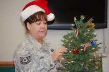 Tech. Sgt. Sharon Loring, 916th Force Support Squadron, decorates the tree in public affairs. (USAF photo by Maj. Shannon Mann, 916ARW/PA)