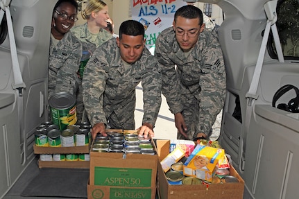 Senior Airmen Jeanette Collins, Jeremy Cook and Danny Gamboa load a van Dec. 9 with food items collected by Airman Leadership School for the San Antonio Food Bank. Members of ALS Class 11-2 collected more than 1,100 pounds of food to support needy families in the community. (U.S. Air Force photo/Antonio Morano)