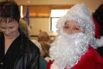 Is that Santa? No, that's Midge!  Midge Hayes, 916th Finance Office, spreads holiday cheer to Maj. Shelley LeVan, 916th Equal Opportunity officer. (USAF photo by Maj. Shannon Mann, 916ARW/PA)