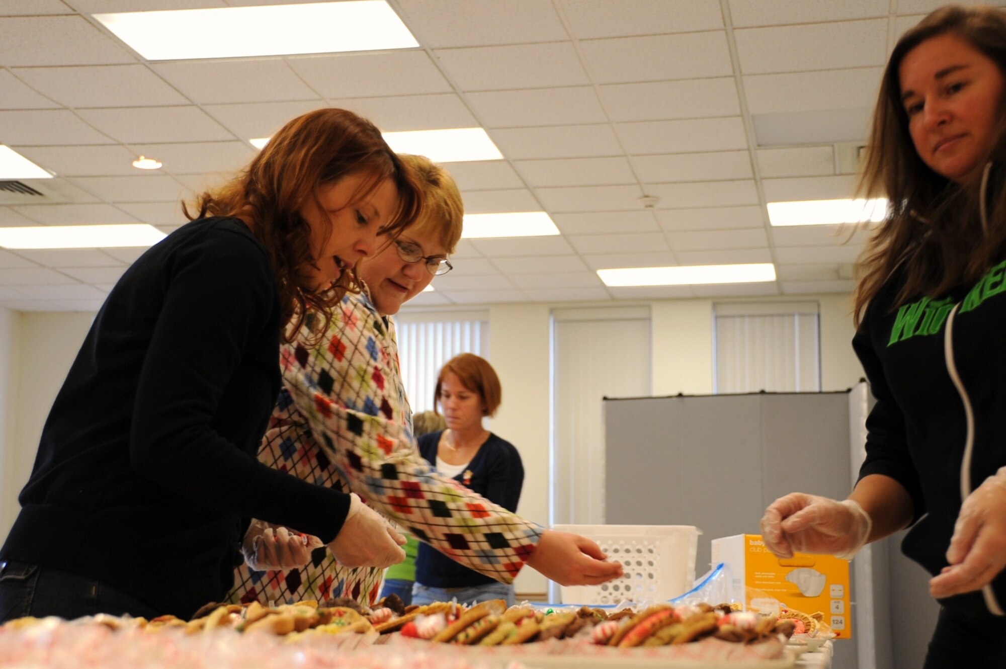 Heidi Luedtke and Valerie Burks, Joint Base McGuire-Dix-Lakehurst spouses, prepare holiday cookie packages for the joint base servicemembers living in the dorms as well as demobilized and mobilized servicemembers at the McGuire Chapel Dec. 15. Cookies were donated by JB MDL community members and local businesses creating more than 1,700 packages. (U.S. Air Force photo/Airman 1st Class Dennis Sloan)