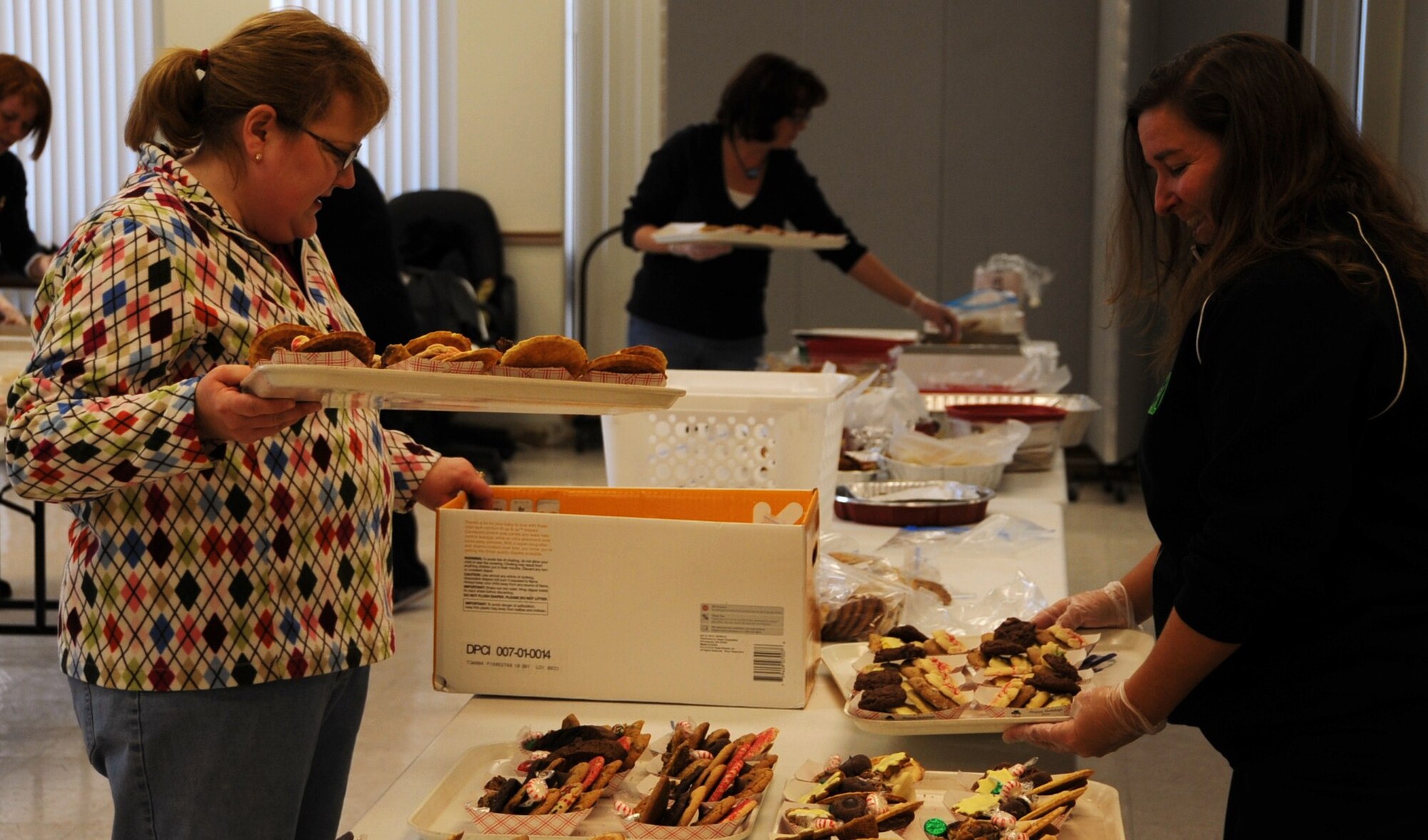 Leslie Boone and Valerie Burks, Joint Base McGuire-Dix-Lakehurst spouses, arrange cookies on a tray Dec. 15 at the McGuire Chapel. The spouses made more than 1,700 holiday cookie packages for joint base servicemembers living in the dorms as well as demobilized and mobilized servicemembers. (U.S. Air Force photo/Airman 1st Class Dennis Sloan)