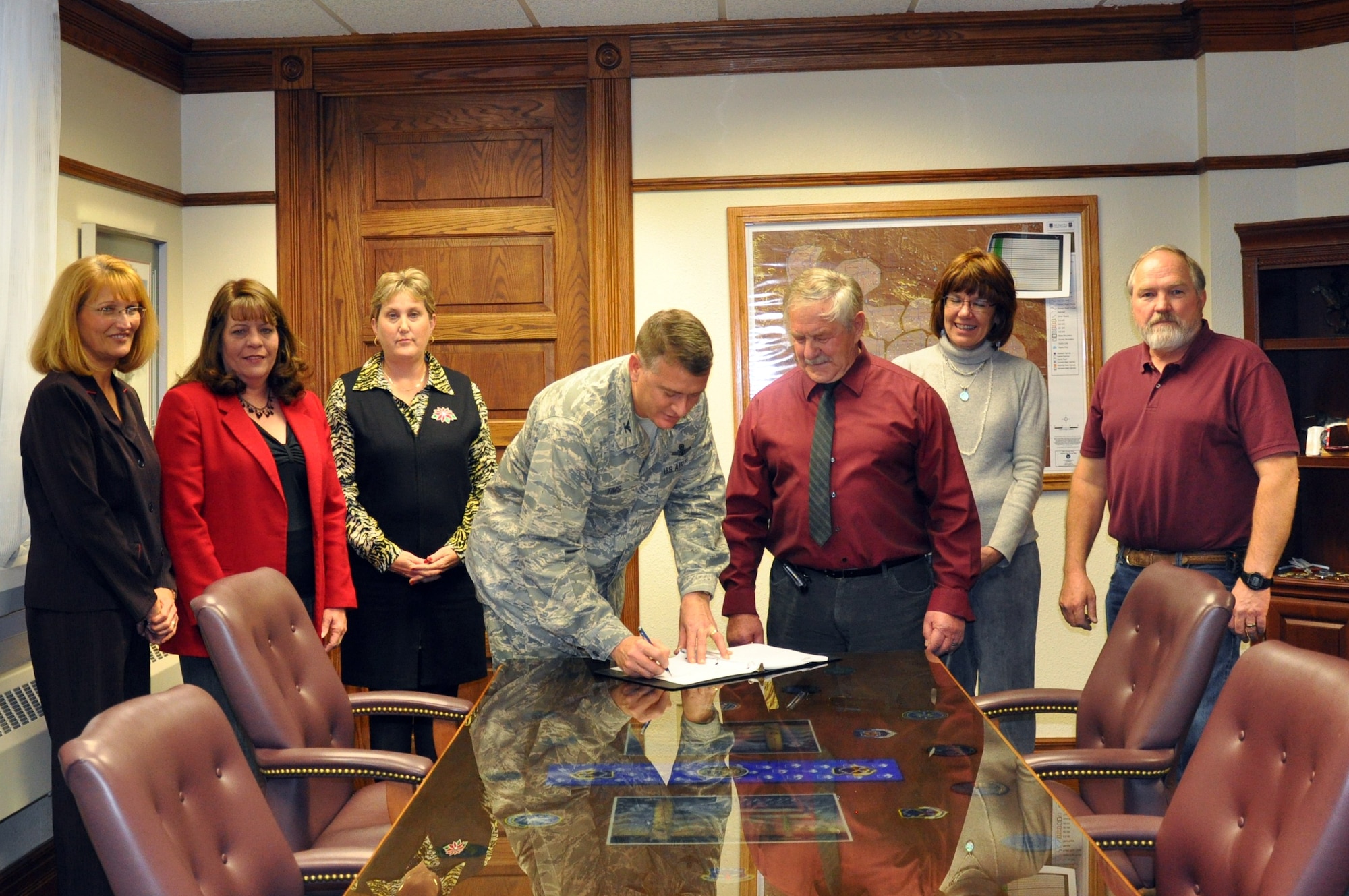 Colonel Greg Tims, 90th Missile Wing commander, signs the new contract between F. E. Warren and American Federation of Government Employees Local 2354. Pictured left to right, Mary Pfau, human resources specialist; Ranea Vosler, civilian personnel officer; Karen Jones, labor relations officer; Colonel Tims; Fran Shive, union president; Shauna Lacey, union vice president; and Chris Story, chief steward. AFGE Local 2354 was chartered on November 1, 1963; initial membership was 53. Walt Robin was the first president; since the charter there have been 14 presidents. The symbolic signing of the memorandum of understanding between Warren AFB and the American Federation of Government Employees, local 2354 signifies the completion of negotiations of a new three year agreement. The agreement includes 33 articles covering a multitude of management, appropriated fund employee, and local Union rights and obligations as they relate to bargaining unit Federal civilian employment at F. E. Warren Air Force Base, Wyo. (U.S. Air Force photo by 2nd Lt. Stacey Fenton)