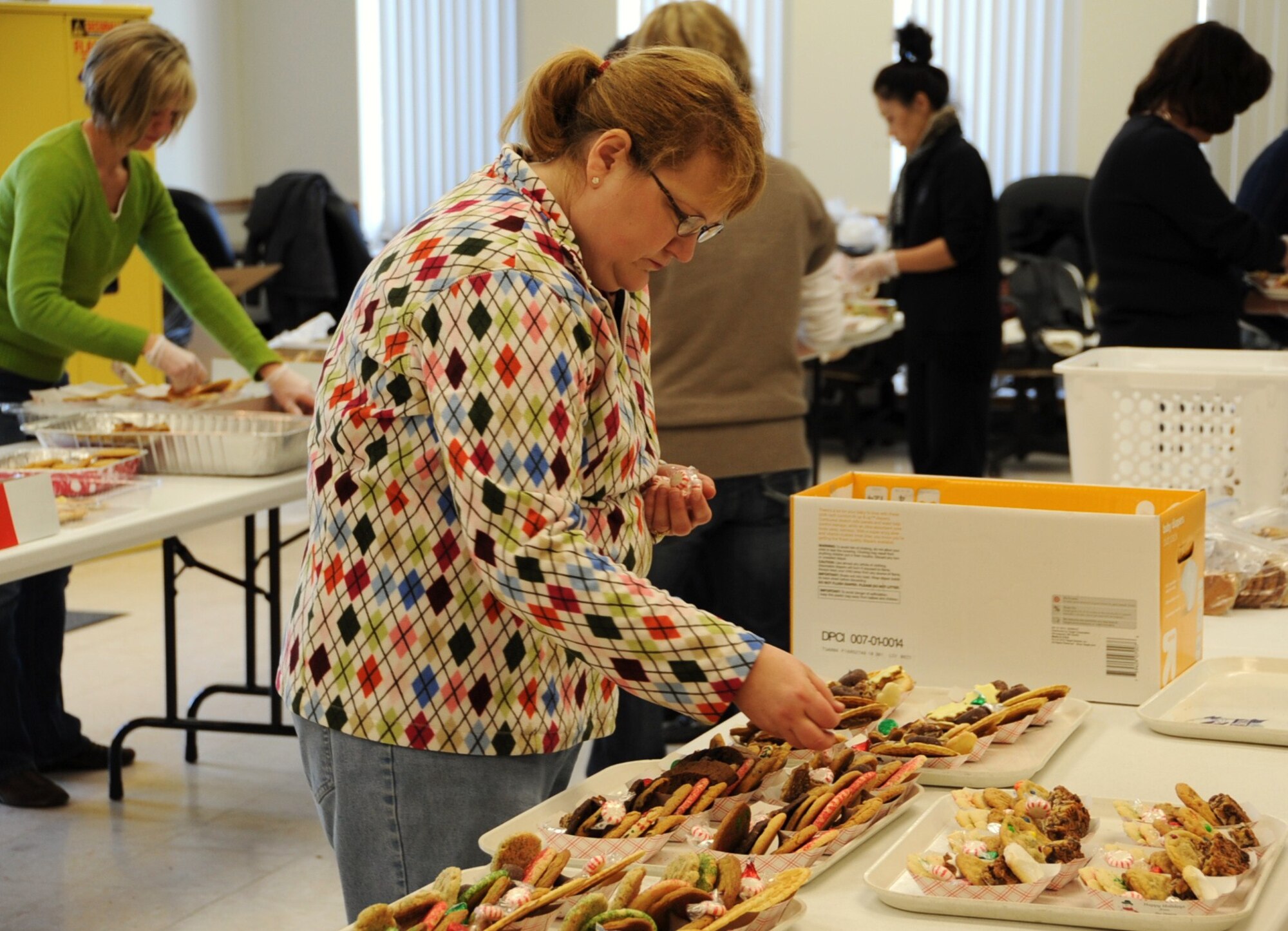 Valerie Burks, Joint Base McGuire-Dix-Lakehurst spouse, adds Hershey kisses and mints to the holiday cookie packages, Dec. 15 at the McGuire Chapel. The packages were given to joint base servicemembers living in the dorms as well as demobilized and mobilized servicemembers. First sergeants from different squadrons picked up the packages and delivered them to servicemembers living in the dormitories. (U.S. Air Force photo/Airman 1st Class Dennis Sloan)