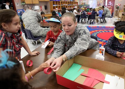 Master Sgt. Christy Hayes, Air Force Intelligence, Surveillance and Reconnaissance Agency, helps Valley Hi Elementary School kindergarten students make a paper chain Dec. 1. Airmen from AFISRA adopted the classroom through the Joint Base San Antonio adopt-a-school program. (U.S. Air Force photo/Robbin Cresswell)