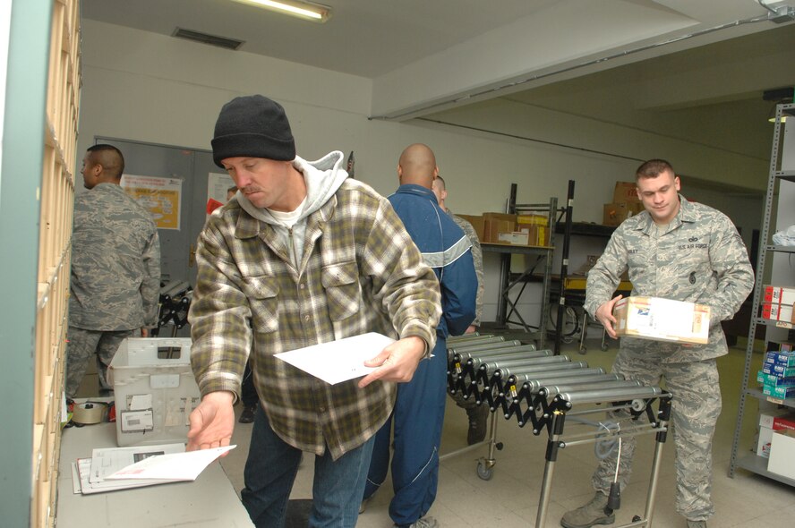Tech. Sgt. Dean Siegrist (foreground), of the 385th Air Expeditionary Group, pitches mail while Staff Sgt. Sean Foley, of the 39th Security Forces Squadron, removes a box from the conveyor. These Airmen volunteered at the Official Document Center Dec. 13, at Incirlik Air Base, Turkey. The ODC needs volunteers this time of year to expedite the delivery of mail to the Incirlik community. (U.S. Air Force photo by Tech. Sgt. Valda Wilson/Released)