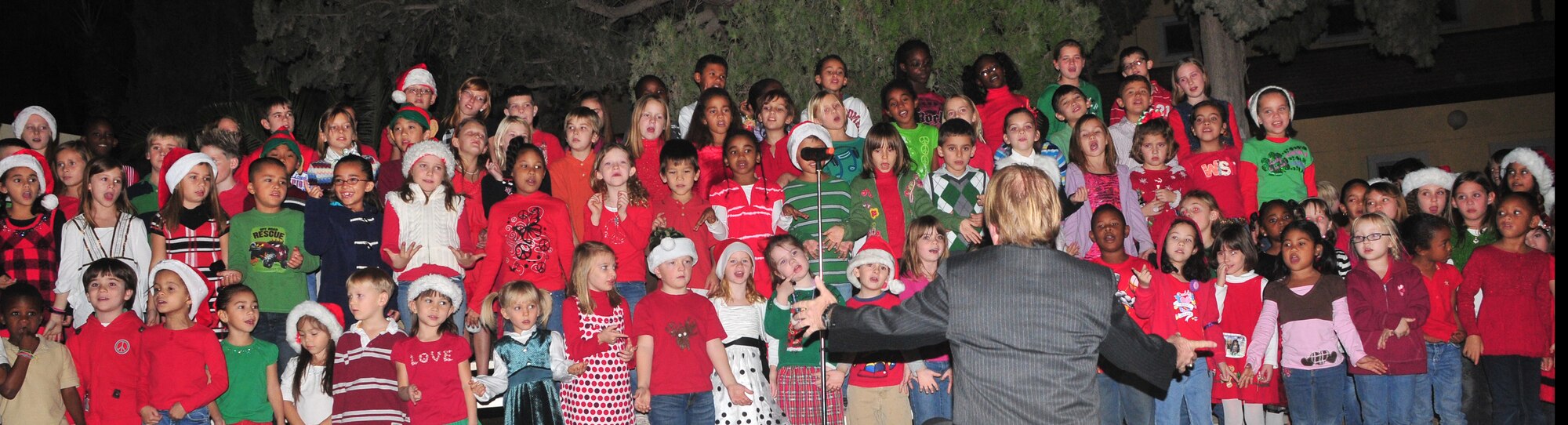 Children from the Incirlik Unit School choir sing carols during the tree lighting ceremony at the base chapel Dec. 3, 2010 at Incirlik Air Base, Turkey. The ceremony is held every year during the holiday season to bring Airmen and their families together by lighting the base holiday tree. (U.S Air Force Photo by Staff Sergeant Alexandre Montes/Released)