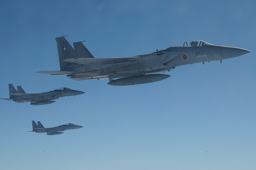 Three F-15J fly through the air during the joint refueling training between the 909th Refueling Squadron and Japan Air Self Defense Forces, Dec. 17. This training improved biliteral relationships between the 18th Wing and JASDF members. (U.S. Air Force photo/Staff Sgt. Darnell T. Cannady)