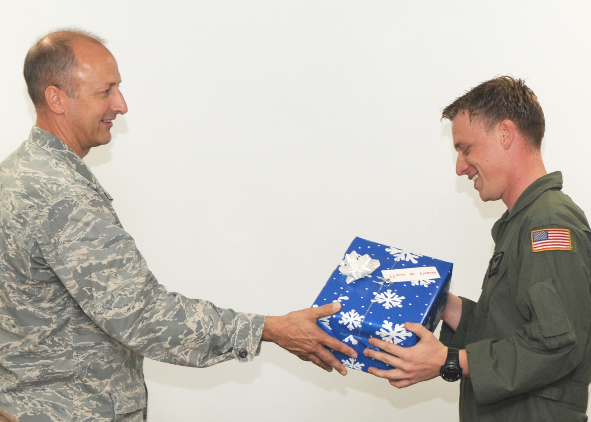 KADENA AIR BASE, Japan -- Col. Robert Toth, the 353rd Special Operations Group commander, hands Staff Sgt. James Kosnosky, a loadmaster with the 1st Special Operations Squadron, a gift here Dec. 21. The gift contains technical sergeant stripes and an order promoting Sergeant Kosnosky  to technical sergeant through the Stripes for Exceptional Performers program. (U.S. Air Force photo by Tech. Sgt. Aaron Cram)