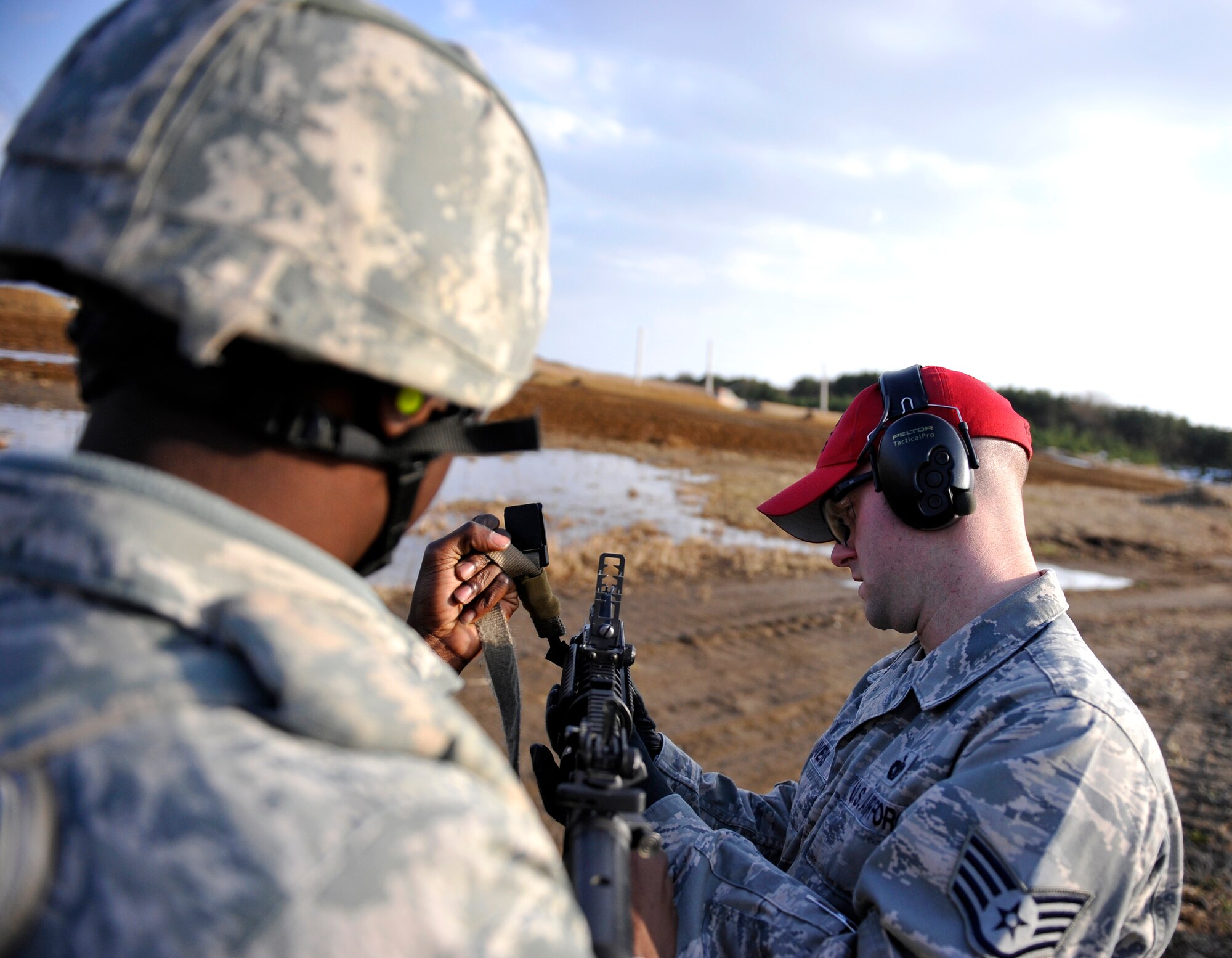 U.S. Air Force Staff Sgt. John Havens, 35th Security Forces Squadron combat arms training and maintenance instructor, assists Airman 1st Class Wayne Abrams, 35th Security Forces Squadron patrolman, before firing an M203 grenade launcher during training Dec. 21, 2010 at Draughon Range, Misawa Air Base, Japan. Airmen received a 2-hour classroom instruction before going to the range for firing. (U.S. Air Force photo by Staff Sgt. Chad C. Strohmeyer)