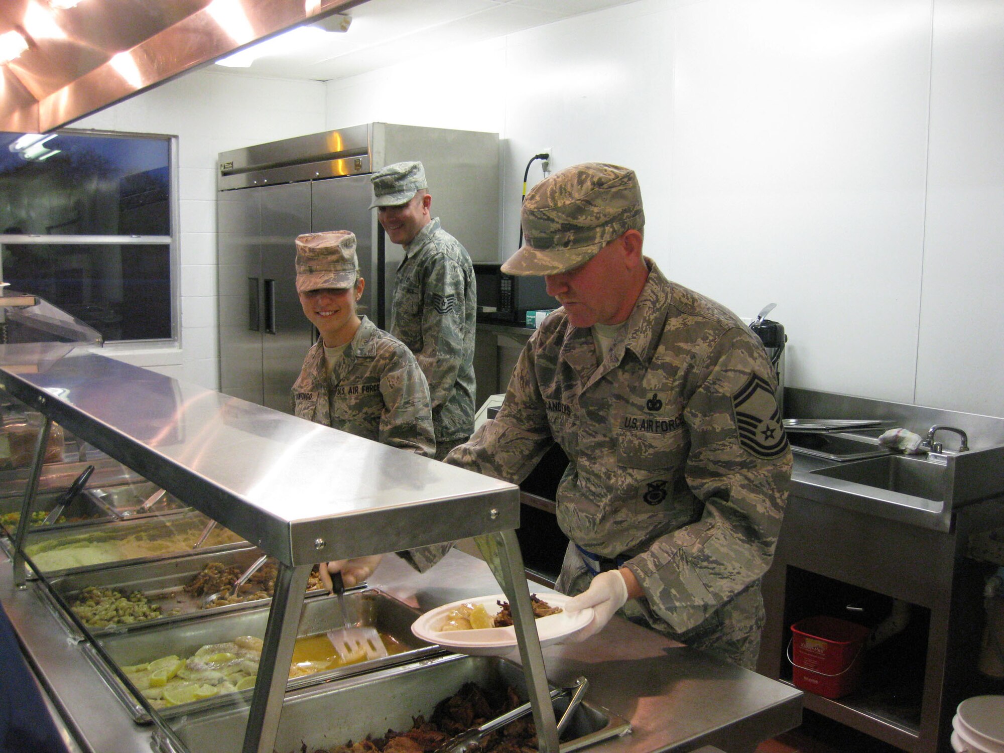 TRAVIS AIR FORCE BASE, Calif. -- Senior Master Sgt. Daryle W. Flanders (Right) of the 507th SFS, Tinker AFB,  assists Airman Basic Danielle Santiago (left) of the 349th MAS with serving dinner to his comrades at Patriot Defender in Mineral Wells, Texas. (U.S. Air Force photo/Master Sgt. Jon Mueller)