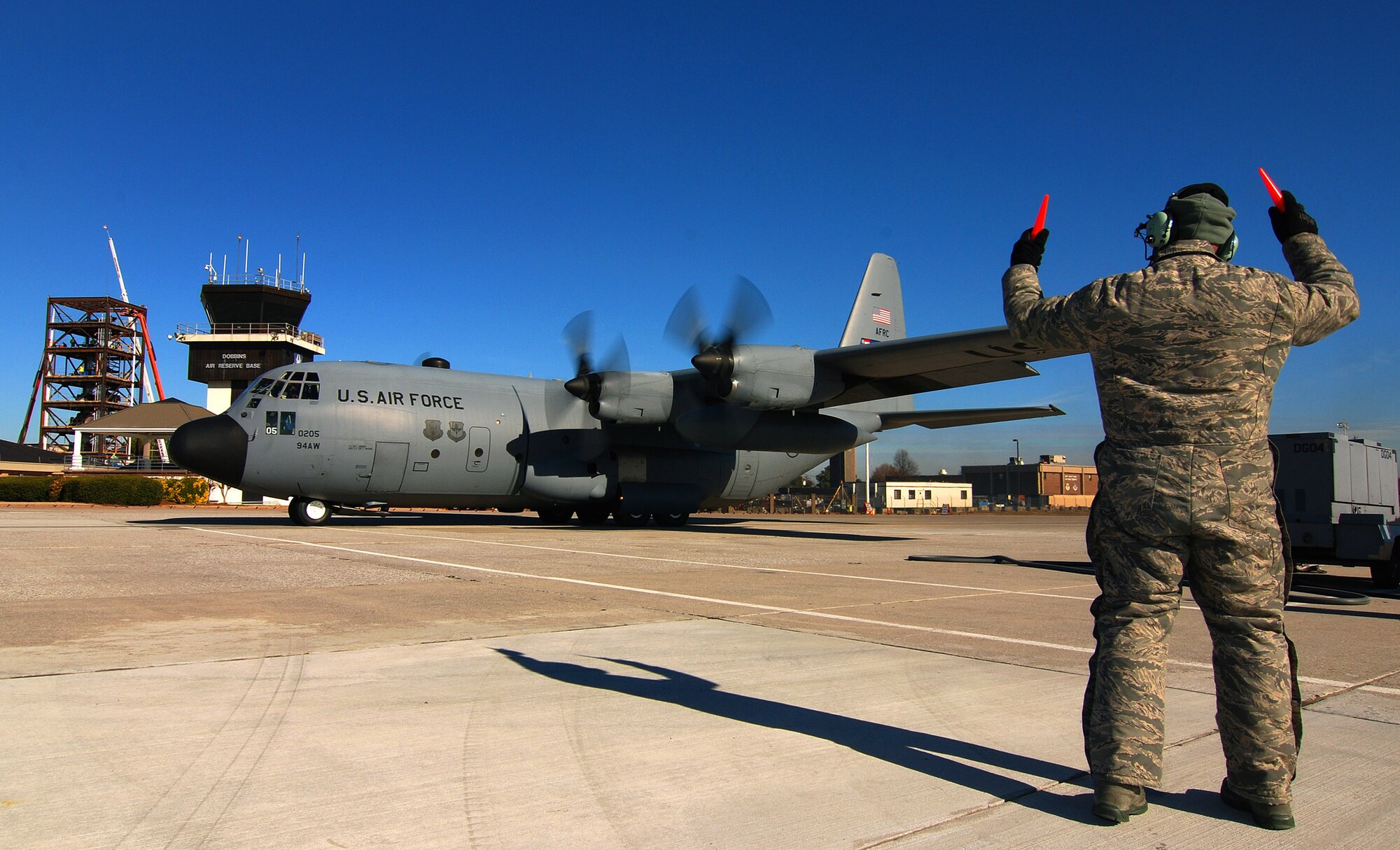 Tech. Sgt. Tim Mansion of the 94th Aircraft Maintenance Flight and dedicated crew chief for this aircraft marshals the C-130H2 Hercules from its parking spot at Dobbins Air Reserve Base, Ga., Dec 20.   The Hercules belongs to the 94th Airlift Wing at Dobbins.   (U.S. Air Force photo/ Brad Fallin)