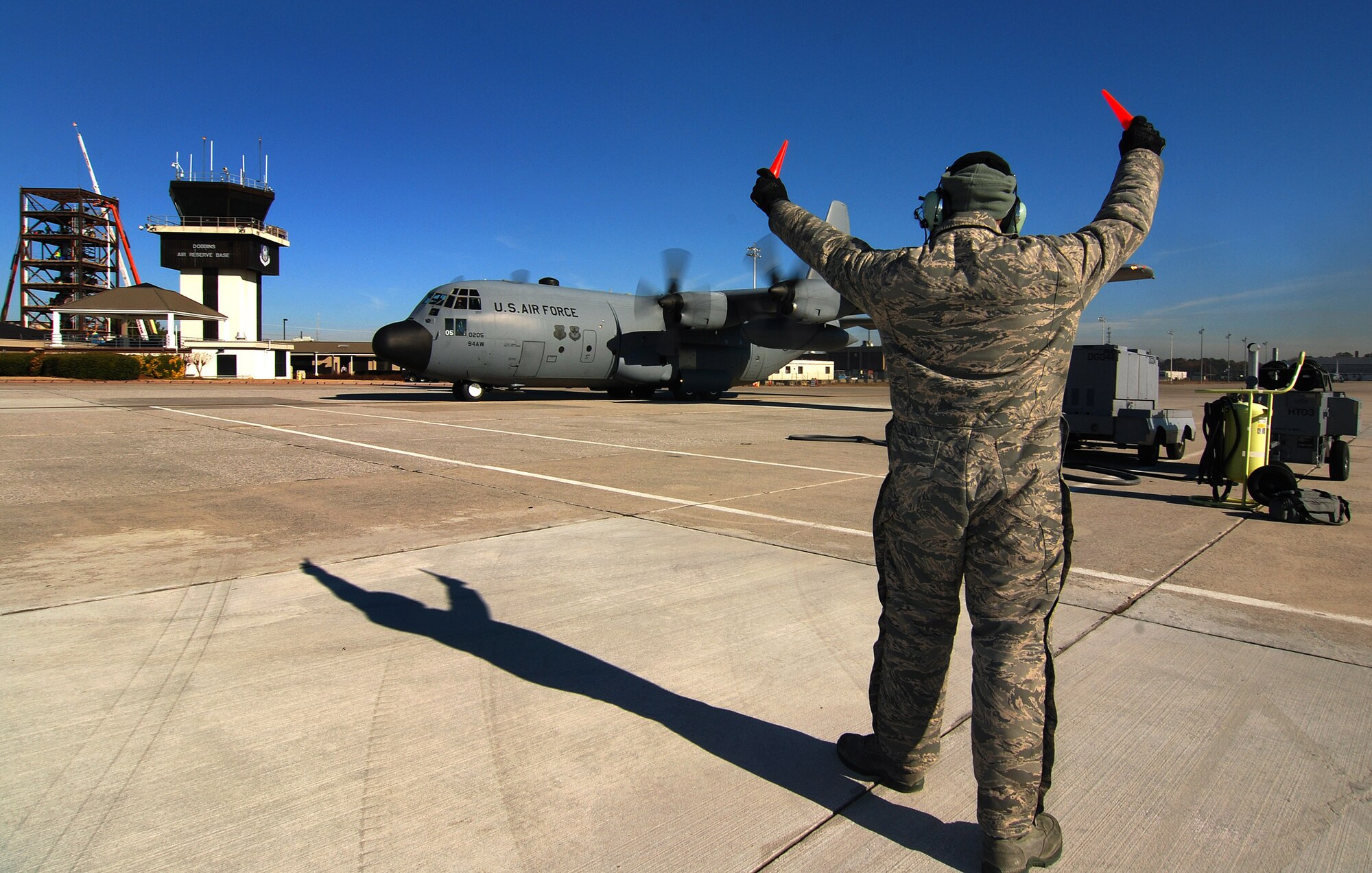 Tech. Sgt. Tim Mansion of the 94th Aircraft Maintenance Flight s and dedicated crew chief for this aircraft signals to the pilot to stand by to taxi the C-130H2 Hercules from its parking spot at Dobbins Air Reserve Base, Ga., Dec 20.   The Hercules belongs to the 94th Airlift Wing at Dobbins.   (U.S. Air Force photo/ Brad Fallin)