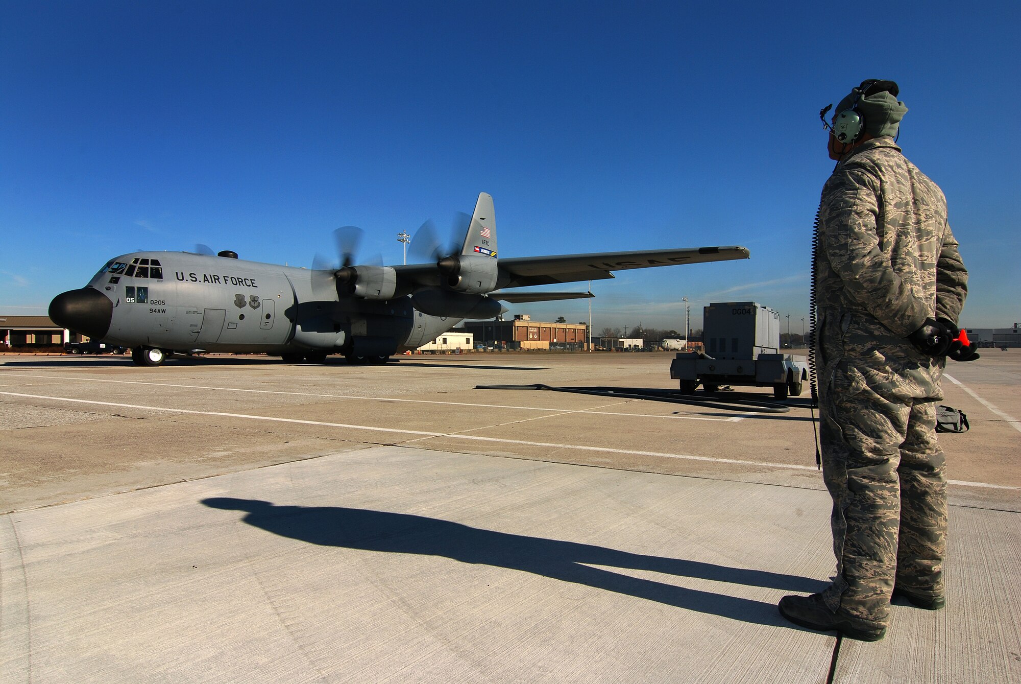Tech. Sgt. Tim Mansion of the 94th Aircraft Maintenance Flight and dedicated crew chief for this aircraft stands by to marshal the C-130H2 Hercules from its parking spot when the pilot is ready to taxi out at Dobbins Air Reserve Base, Ga., Dec 20.   The Hercules belongs to the 94th Airlift Wing at Dobbins.   (U.S. Air Force photo/ Brad Fallin)