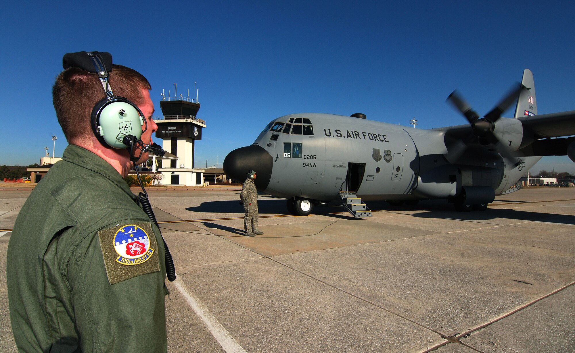 Senior Airman Brett Grove a loadmaster with the 700th Airlift Squadron communicates with the rest of the C-130H2 Hercules aircrew as he monitors the start of the number two engine at Dobbins Air Reserve Base, Ga., Dec 20.    Tech. Sgt. Tim Mansion of the 94th Aircraft Maintenance Flight and the dedicated crew chief for this aircraft stands by to monitor the engine start.  The Hercules belongs to the 94th Airlift Wing at Dobbins.   (U.S. Air Force photo/ Brad Fallin)