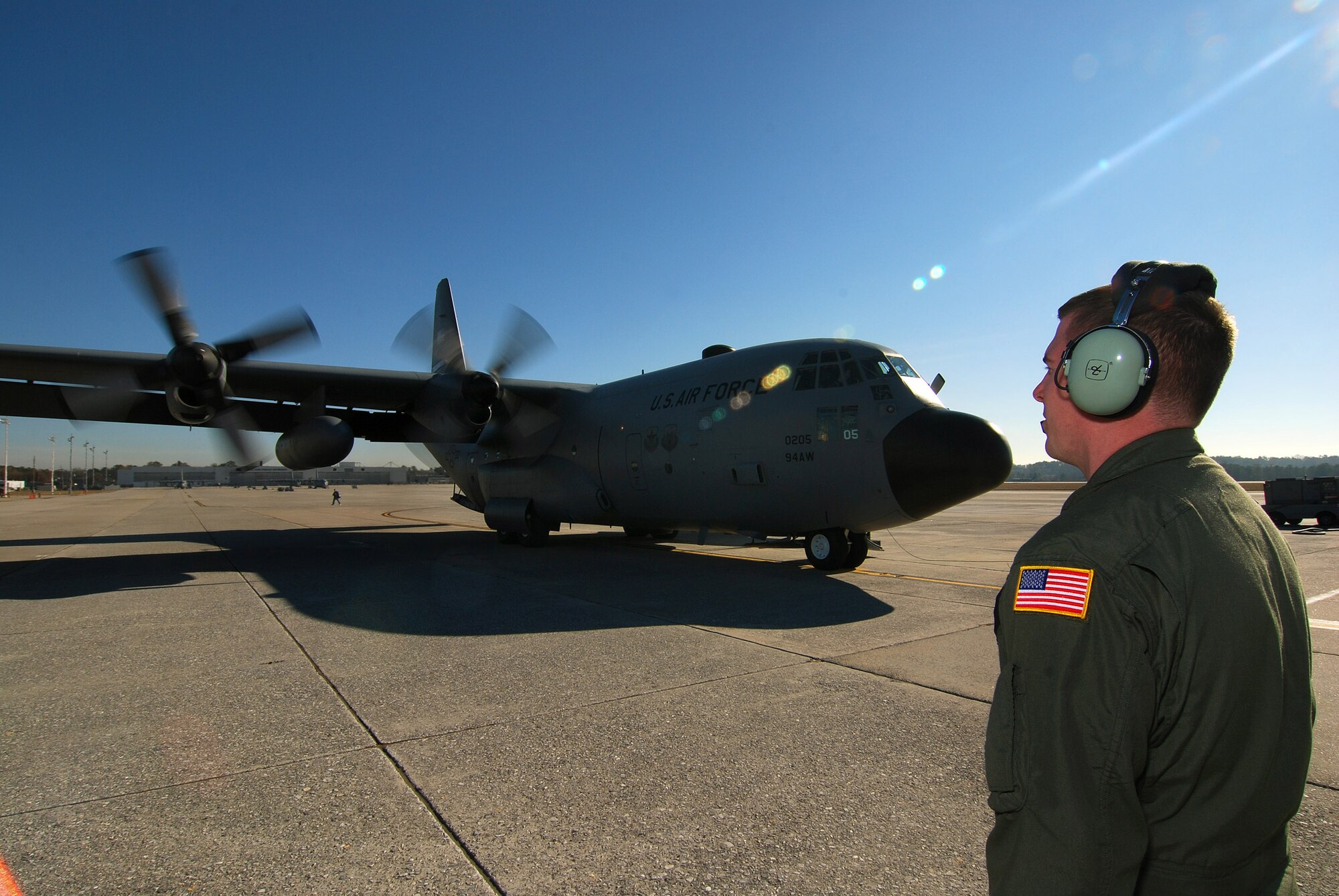 Senior Airman Brett Grove a loadmaster  with the 700th Airlift Squadron communicates with the rest of the C-130H2 Hercules aircrew as he monitors the start of the number four engine on the outboard pylon at Dobbins Air Reserve Base, Ga., Dec 20.   The Hercules belongs to the 94th Airlift Wing at Dobbins.   (U.S. Air Force photo/ Brad Fallin)