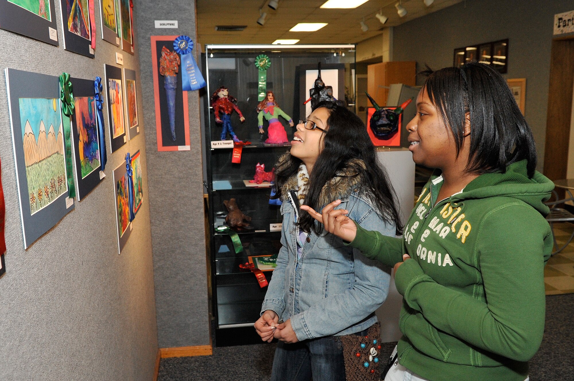 Giselis Nieves, daughter of Jesus Nieves, 305th Aerial Support Squadron, and Rachel Jones, daughter of Master Sgt. (retired) Mark Jones, 305th APS, take a look at results of the Boys and Girls Club of America Fine Arts Exhibit judging at the JB MDL Arts & Crafts Center held Dec. 14-18. Giselis took 1st in Watercolors and Rachel took 1st Pastel. (U.S. Air Force photo/Wayne Russell)