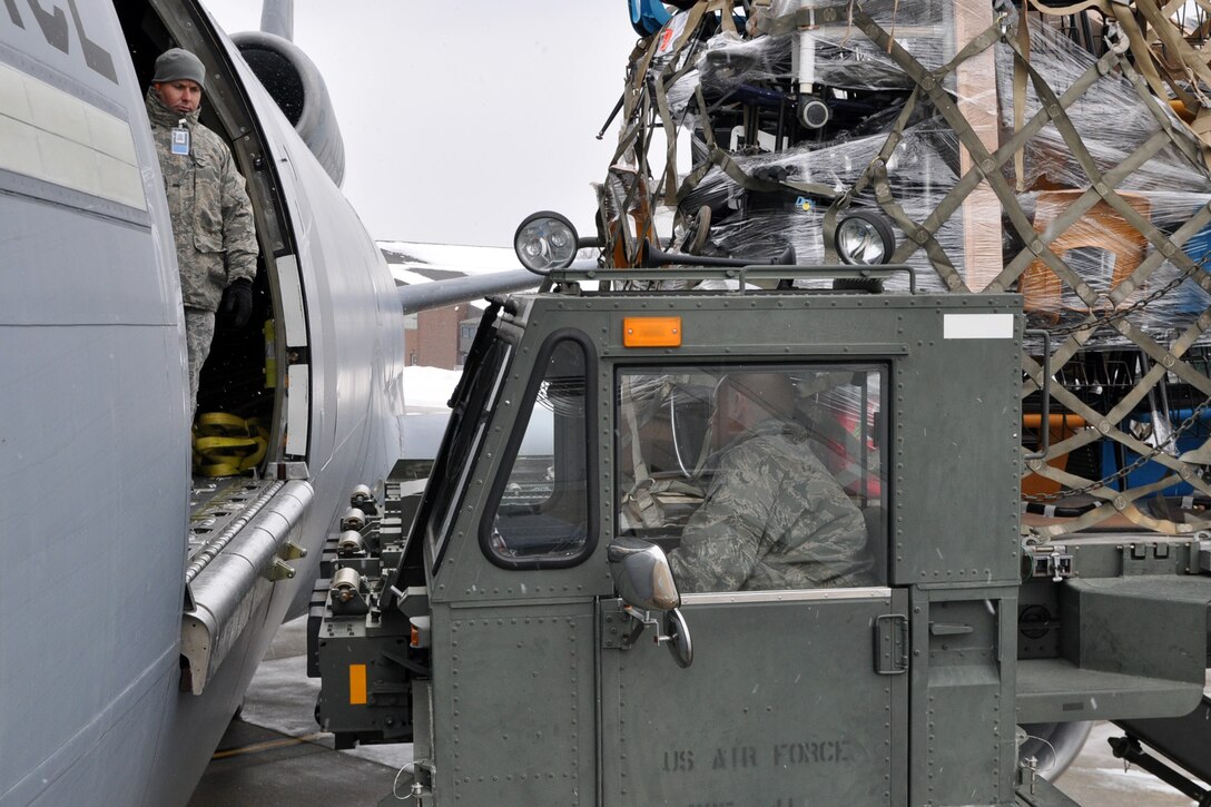 YOUNGSTOWN AIR RESERVE STATION, Ohio -- Air Force Reserve Master Sgt. Kevin Massie, superintendent of the 76th Aerial Post Squadron, based here, watches as Tech. Sgt. Tom Kocis, a aerospace maintenance craftsman assigned to the 910th aerial spray maintenance flight, also based here, moves a ground cargo handling vehicle, known as a "k-loader" towards the hatch of a KC-10 cargo aircraft on the YARS flighline, Dec. 17. Sergeants Massie and Kocis are part of an effort to transport 47,500 pounds of humanitarian cargo collected by Austintown, Ohio-based "Mission of Love" for residents in the communities of Santa Rita, Yora ~ Honduras affected by flooding and mudslides in hopes the aid will brighten their Christmas and holiday season. The KC-10 cargo aircraft is assigned to the 514th Air Mobility Wing, based at McGuire Air Force Base, NJ. Air Force Reservists from the 514th will transport the humanitarian aid to the east coast where it will then be flown to its ultimate destination in Central America. "Mission of Love" is a non-profit organization that provides humanitarian aid to those in need worldwide, especially children. The group is working with the U.S. Air Force Reserve through the Denton Program, which allows private U.S. citizens and organizations to use space available on U.S. military cargo planes to transport humanitarian goods, such as clothing, food, medical and educational supplies, agricultural equipment and vehicles, to countries in need. The program is jointly administered by a government agency known as USAID, the Department of State (DOS), and the Department of Defense (DOD). U.S. Air Force photo by Master Sgt. Bob Barko Jr.