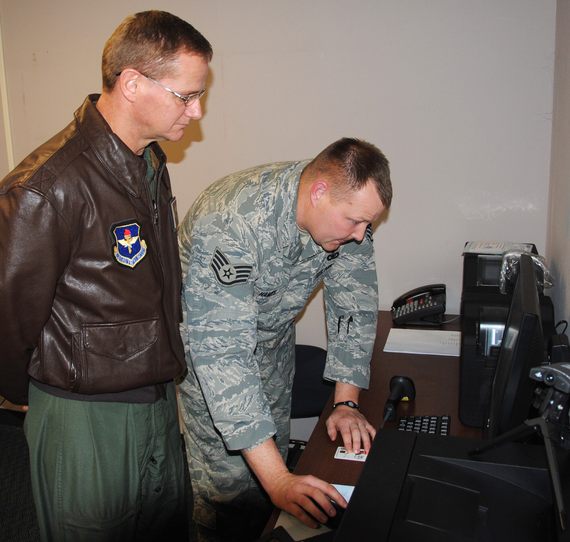 Staff Sgt. Curtis Hames, right, with the 71st Security Forces Squadron at Vance, registers Col. Russ Mack’s common access card into the new Defense Biometric Identification System. Colonel Mack, the 71st Flying Training Wing commander, and other senior Wing leaders were the first active-duty Team Vance members registered Monday, Dec. 20. The DBID system will enhance and standardize base-entry security at Air Force bases throughout the Central time zone. (U.S. Air Force photo/ 2nd Lt. Tyler Gross)