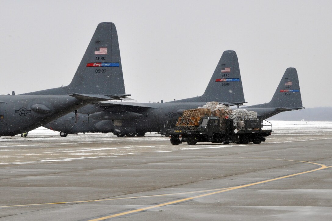 YOUNGSTOWN AIR RESERVE STATION, Ohio -- A ground cargo handling vehicle, known as a "K-loader" moves across the flightline here, Dec. 17. The vehicle is carrying several pallets of humanitarian cargo collected by Austintown, Ohio-based "Mission of Love," a non-profit organization that provides humanitarian aid to those in need worldwide, especially children. The cargo is bound for Santa Rita, Yora ~ Honduras to help residents there affected by flooding and mudslides in hopes the aid will brighten their Christmas and holiday season. The 47,500 pounds of cargo will be loaded aboard KC-10 cargo assigned to the 514th Air Mobility Wing, based at McGuire Air Force Base, NJ. Air Force Reservists from the 514th will transport the humanitarian aid to the east coast where it will then be flown to its ultimate destination in Central America. The "Mission of Love" organization is working with the U.S. Air Force Reserve through the Denton Program, which allows private U.S. citizens and organizations to use space available on U.S. military cargo planes to transport humanitarian goods, such as clothing, food, medical and educational supplies, agricultural equipment and vehicles, to countries in need. The program is jointly administered by a government agency known as USAID, the Department of State (DOS), and the Department of Defense (DOD). U.S. Air Force photo by Master Sgt. Bob Barko Jr. 
    