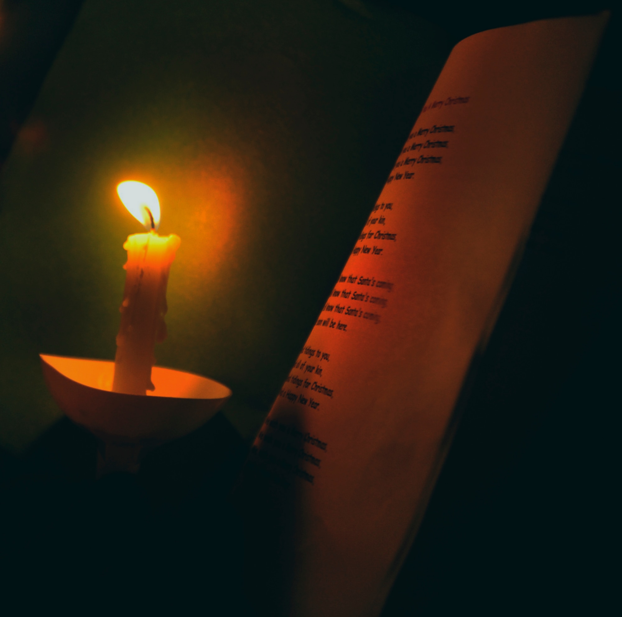 MOODY AIR FORCE BASE, Ga.-- A caroler uses their candle to read the holiday songs as they sing to dorm residents Dec. 8. The group sang songs including, Santa Claus is Coming to Town and Rudolph the Red Nosed Reindeer. (U.S. Air Force photo/Airman 1st Class Nicholas Benroth)(RELEASED)