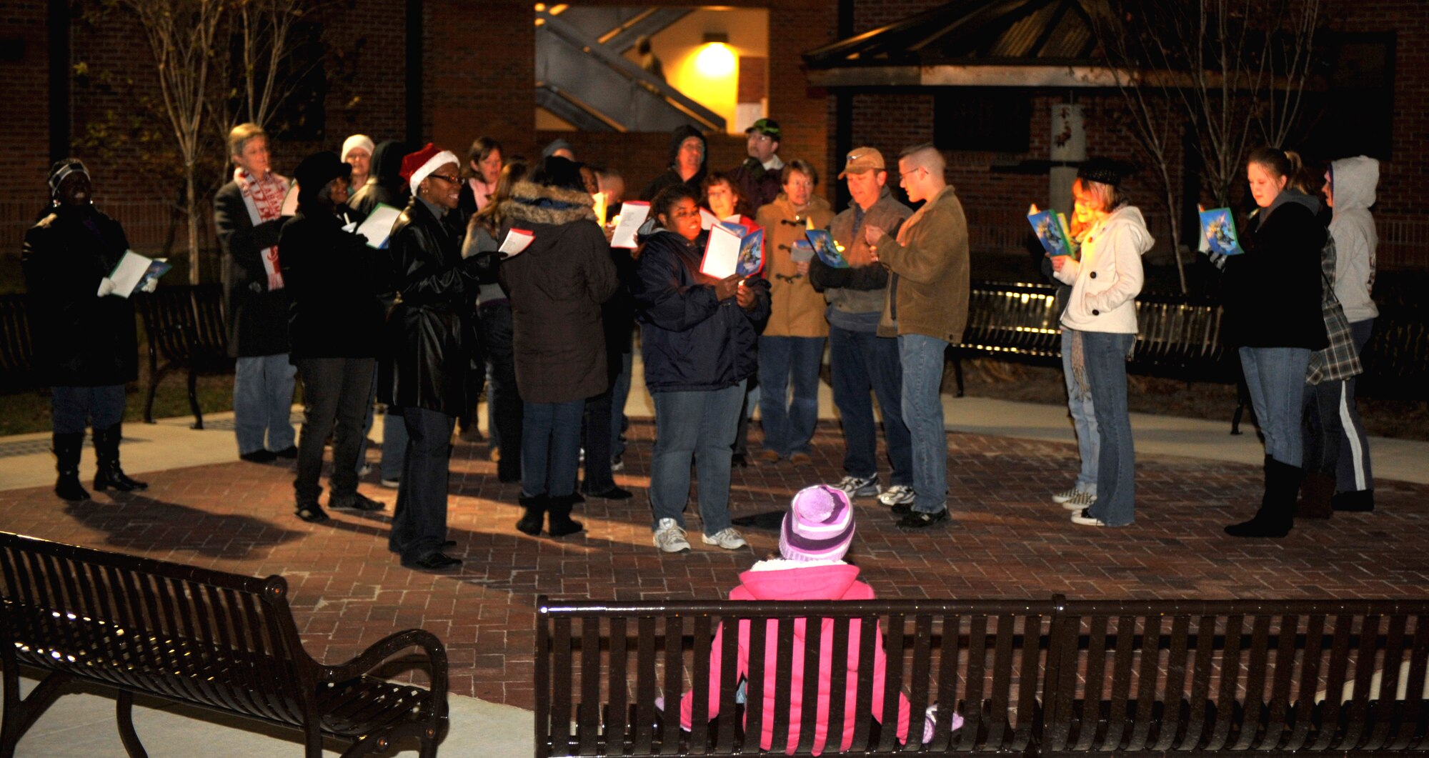 MOODY AIR FORCE BASE, Ga.-- A group of carolers huddled up using only candle light to read versus from holiday songs Dec. 8. The group was outside for an hour and a half singing to residents of the dorms. (U.S. Air Force photo/Airman 1st Class Nicholas Benroth)(RELEASED)