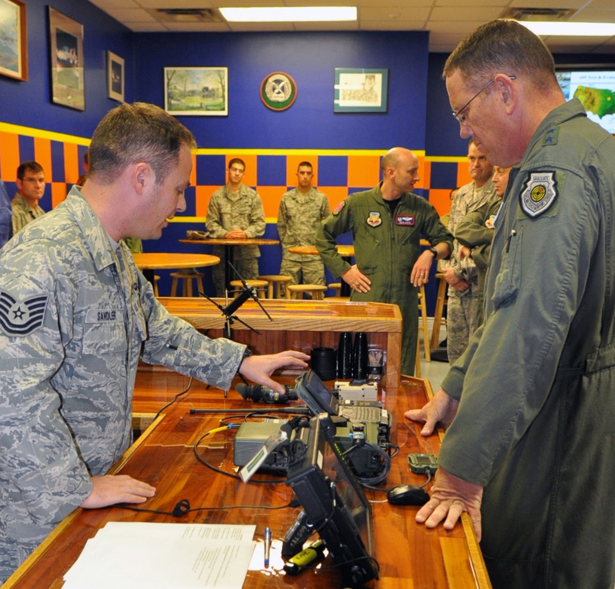 TSgt. Nathan Sandler, front left, briefs U.S. Air Warfare Center Commander Maj. Gen. Bill Hyatt about various tactical air control party equipment the 605th Test and Evaluation Squadron is testing. Sergeant Sandler is a TACP and administers operational system tests for his fellow Airmen who will use the equipment in the field. General Hyatt and Command Chief CMSgt. Robert Sealey, both new to their positions, received immersion briefings and facility tours Dec. 16 of the 505th CCW at Hurlburt Field, Fla., and 53rd Wing at Eglin Air Force Base, Fla. The center oversees operations of both wings. (U.S. Air Force photo/Bill Dowell)